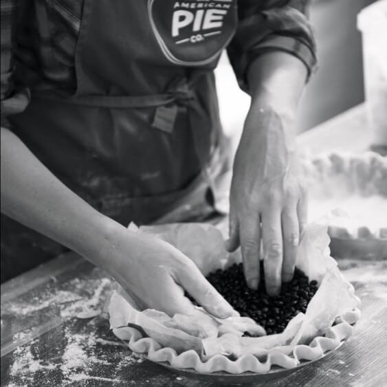 Person preparing a pie in the kitchen