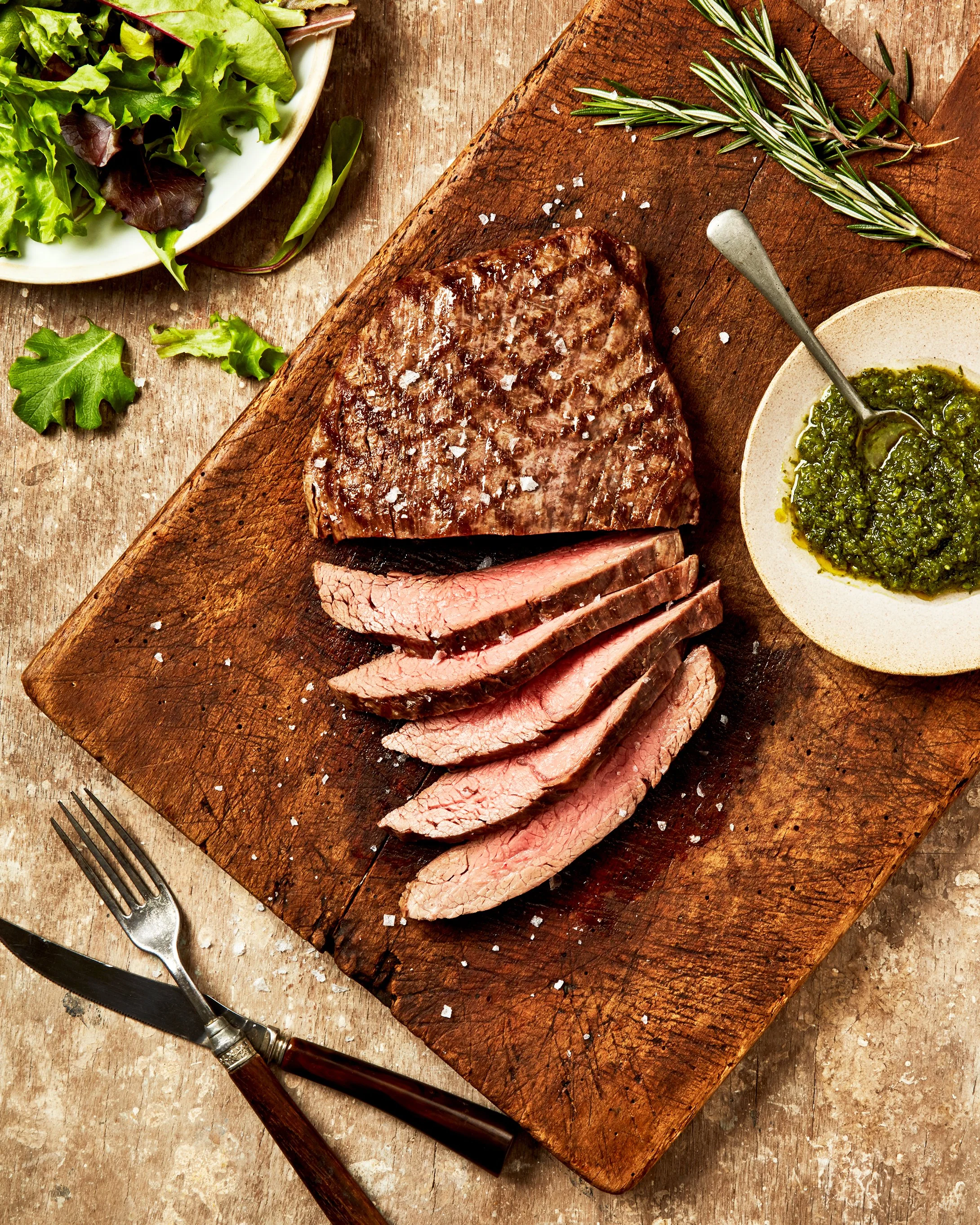 Classic flank steak sliced with chimichuri and salad - food styling, commercial food stylist NYC