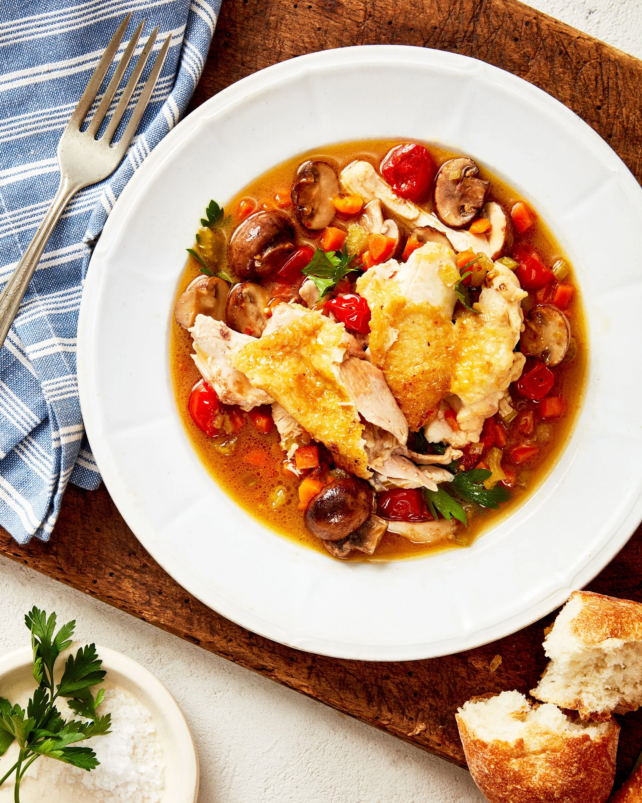 A bowl of slow baked French country chicken with mushrooms, tomatoes and vegetables, photographed by Emily Dryden - food styling, commercial food stylist NYC