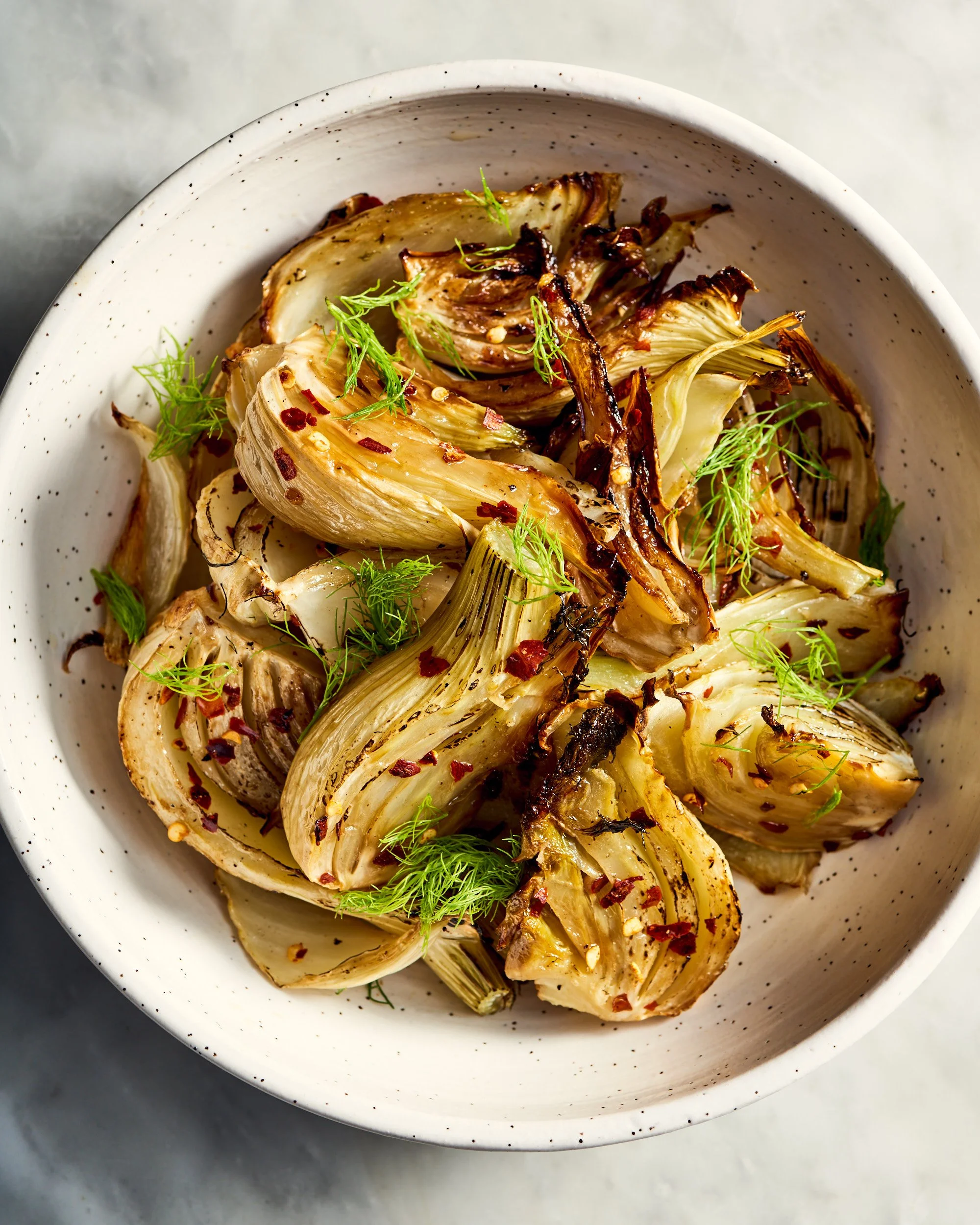 A bowl of roasted fennel bulbs with olive oil and chili flakes, photographed by Julia Gartland for The Kitchn - food styling, commercial food stylist NYC