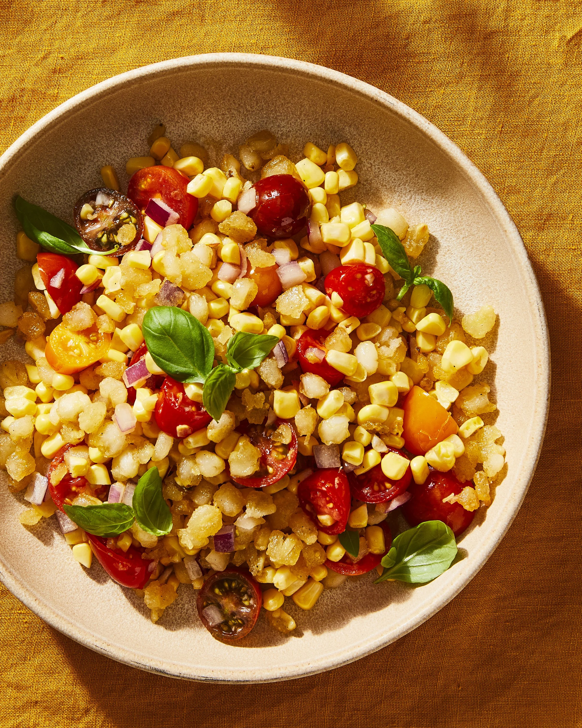 A bowl of hominy salsa with cherry tomatoes and basil, photographed by Julia Gartland for The Kitchn - food styling, commercial food stylist NYC