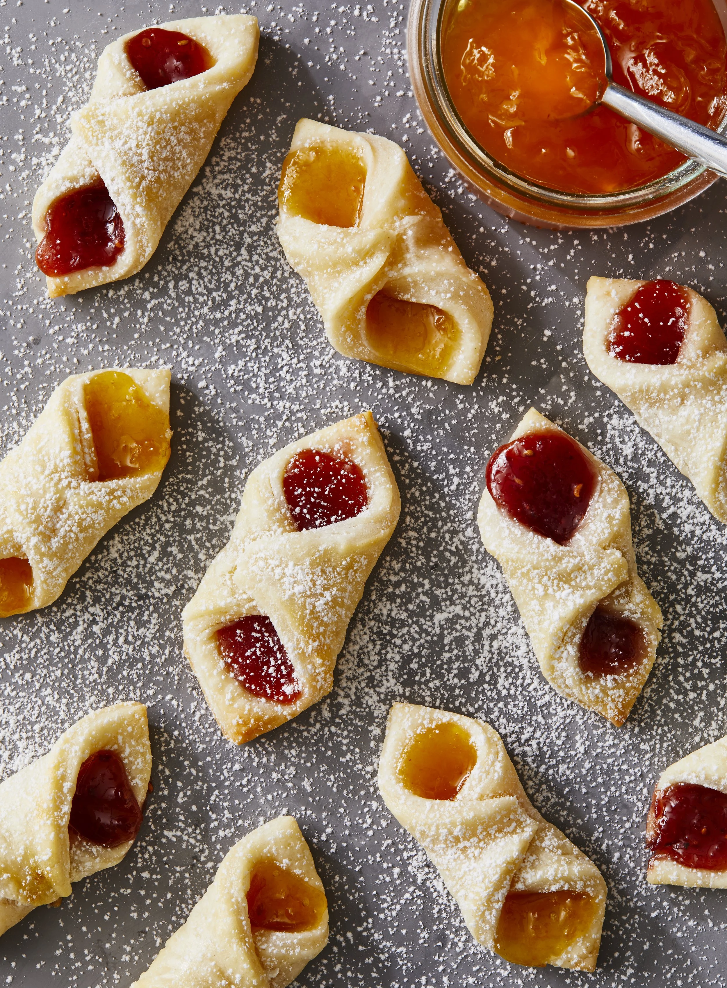 Parcel Cookies of apricot and strawberry jam on a surface with icing sugar sprinkling on top, photographed by Rachel Vanni for Delicious magazine - food styling, commercial food stylist NYC