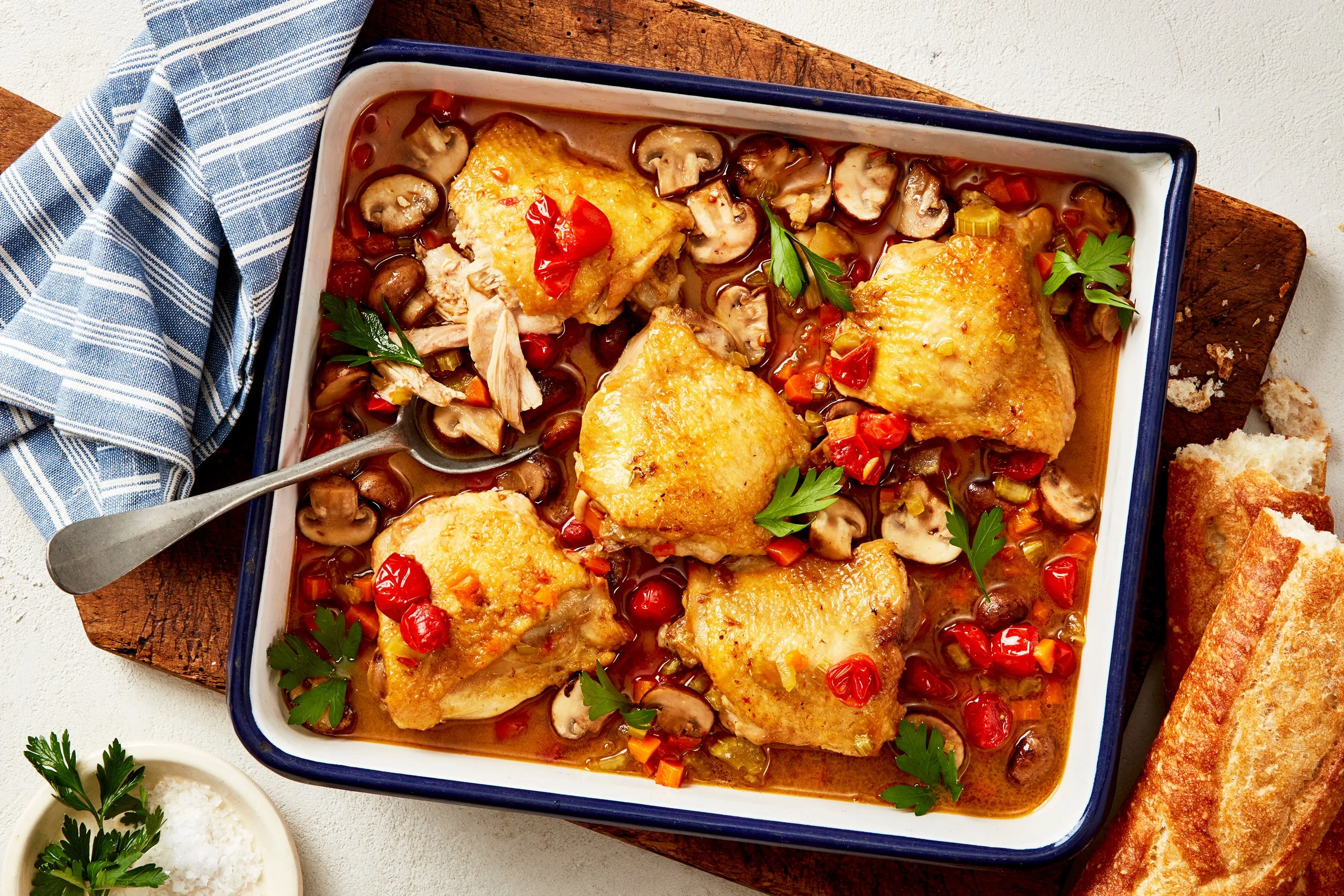 A bowl of slow baked French country chicken with mushrooms, tomatoes and vegetables, photographed by Emily Dryden - food styling, commercial food stylist NYC