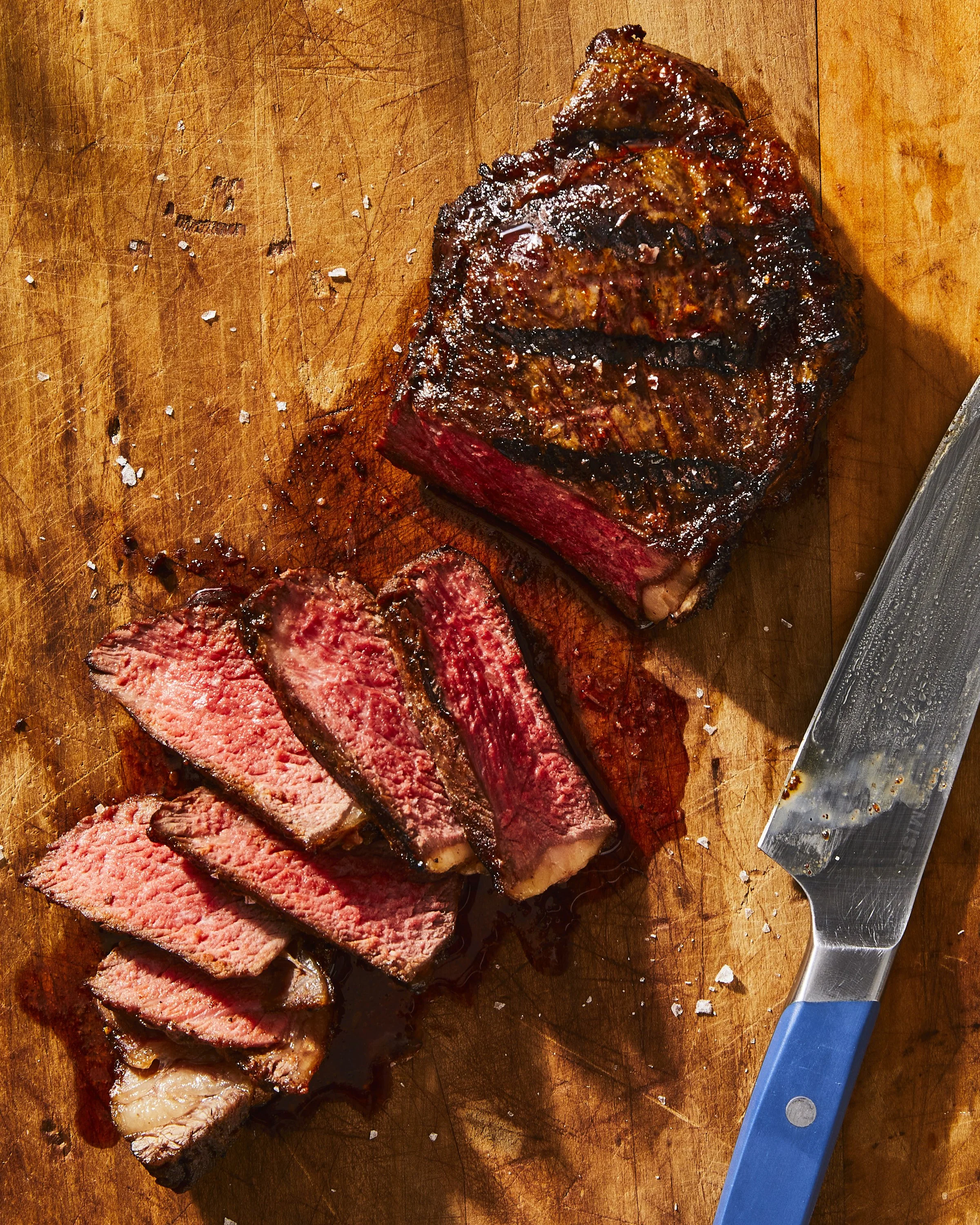 Perfect rare new york strip steak on cutting board - food styling, commercial food stylist NYC