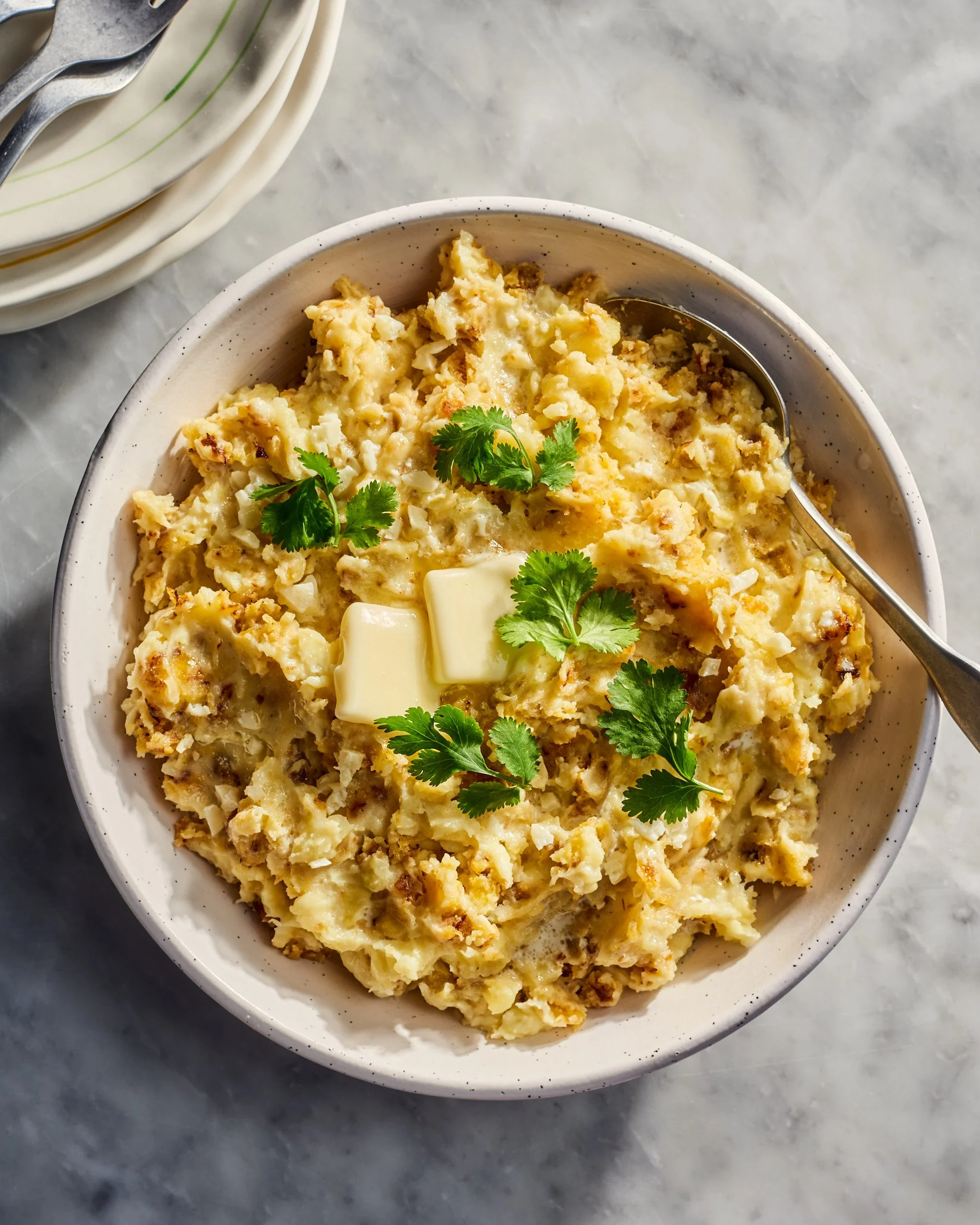 A bowl of mashed mofongo with cilantro and butter melting, photographed by Julia Gartland for The Kitchn - food styling, commercial food stylist NYC
