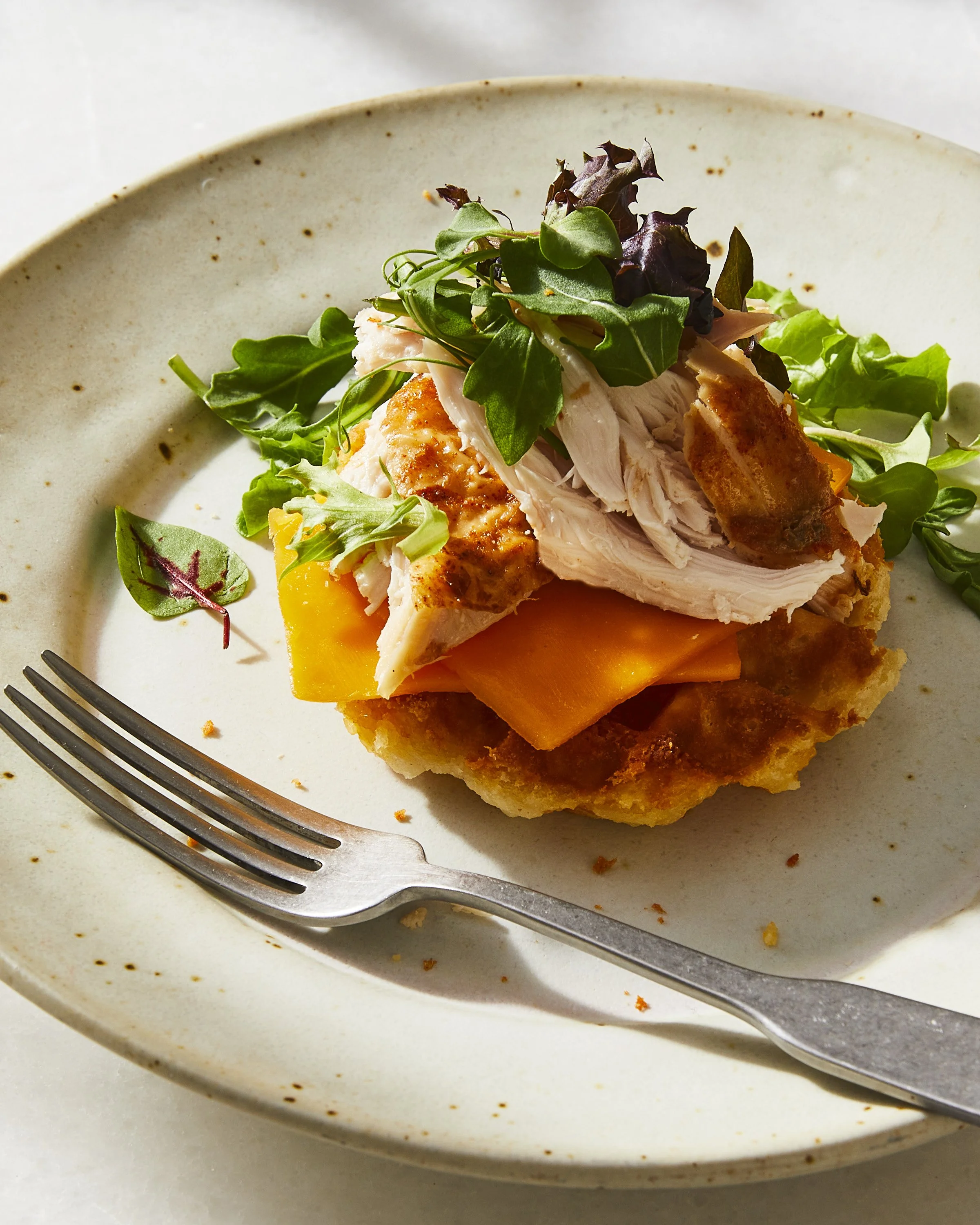 A place of a Thanksgiving leftover dish with a mini waffle, cheese and leftover roasted turkey and salad, photographed by Julia Gartland for The Kitchn - food styling, commercial food stylist NYC