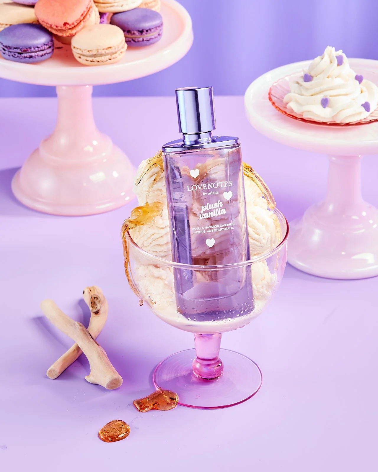 Bottle of Ariana Grande 'Love Notes' perfume bottle in a bowl of ice cream drizzled with caramel with whipped cream and macaroons in the background , photographed by Jeff Harris for Sephora campaign - food styling, commercial food stylist NYC
