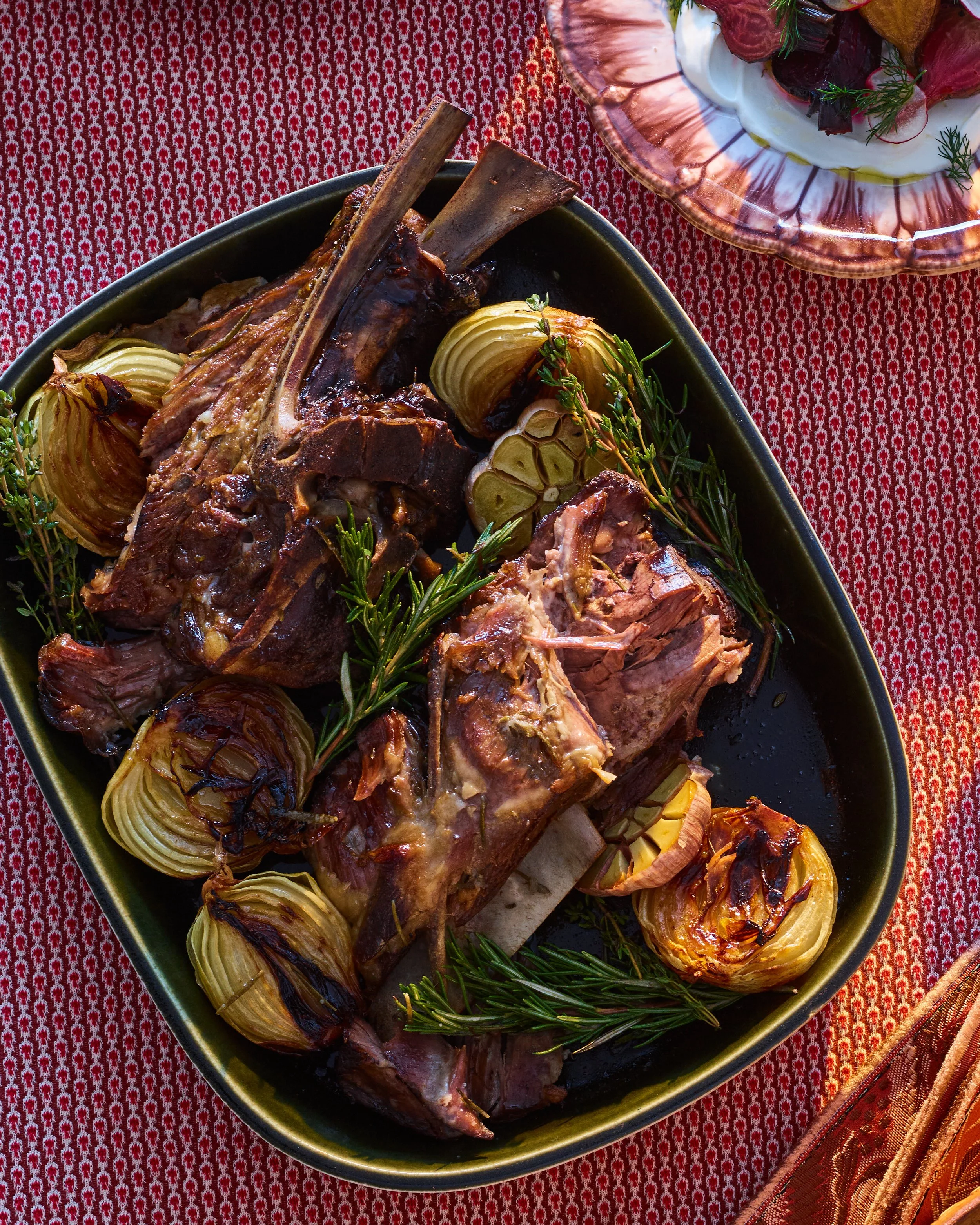 A platter of a slow roasted lamb shoulder with baked onions and rosemary, photographed by James Ransom for a Concept shoot - food styling, commercial food stylist NYC