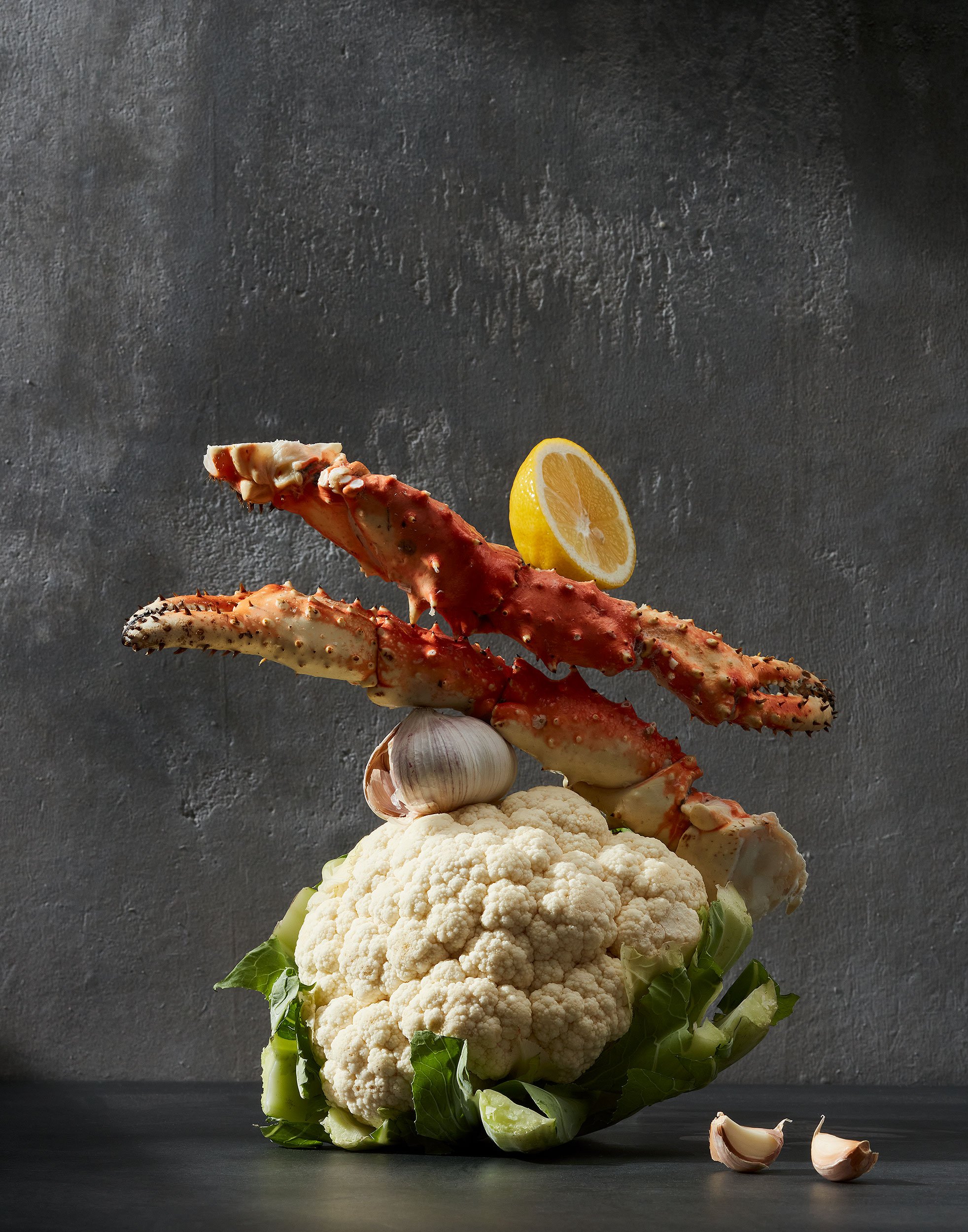 Omega3 rich food in their original form, Cauliflower, garlic, and king crab claws, all balancing on top of each other - photographed by Yunhee Kim - food styling, commercial food stylist NYC