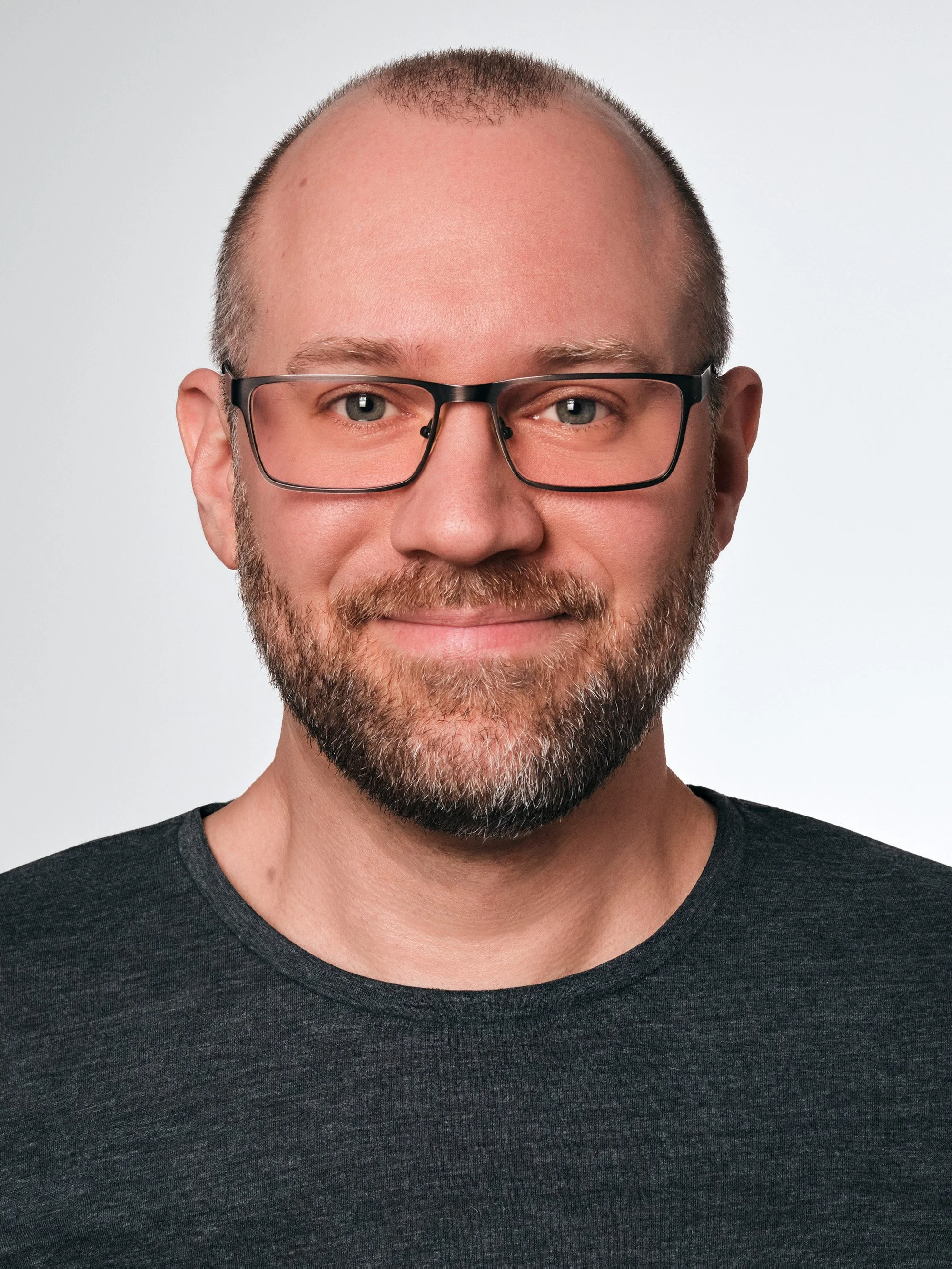 Business Portrait Berlin – Mann mit Brille im dunklen T-Shirt, Studioportrait