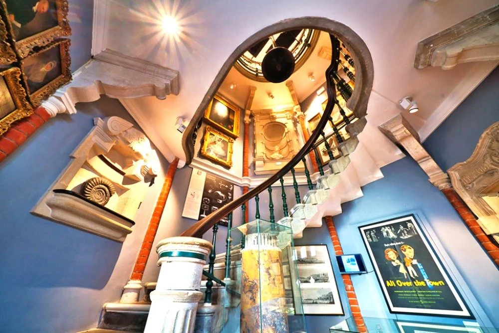 Victorian spiral staircase and nearby wall displays inside the Lyme Regis Museum