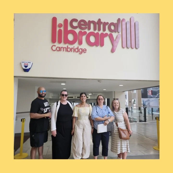 5 people stood in height order underneath a sign for Cambridge Central Library in a team building exercise