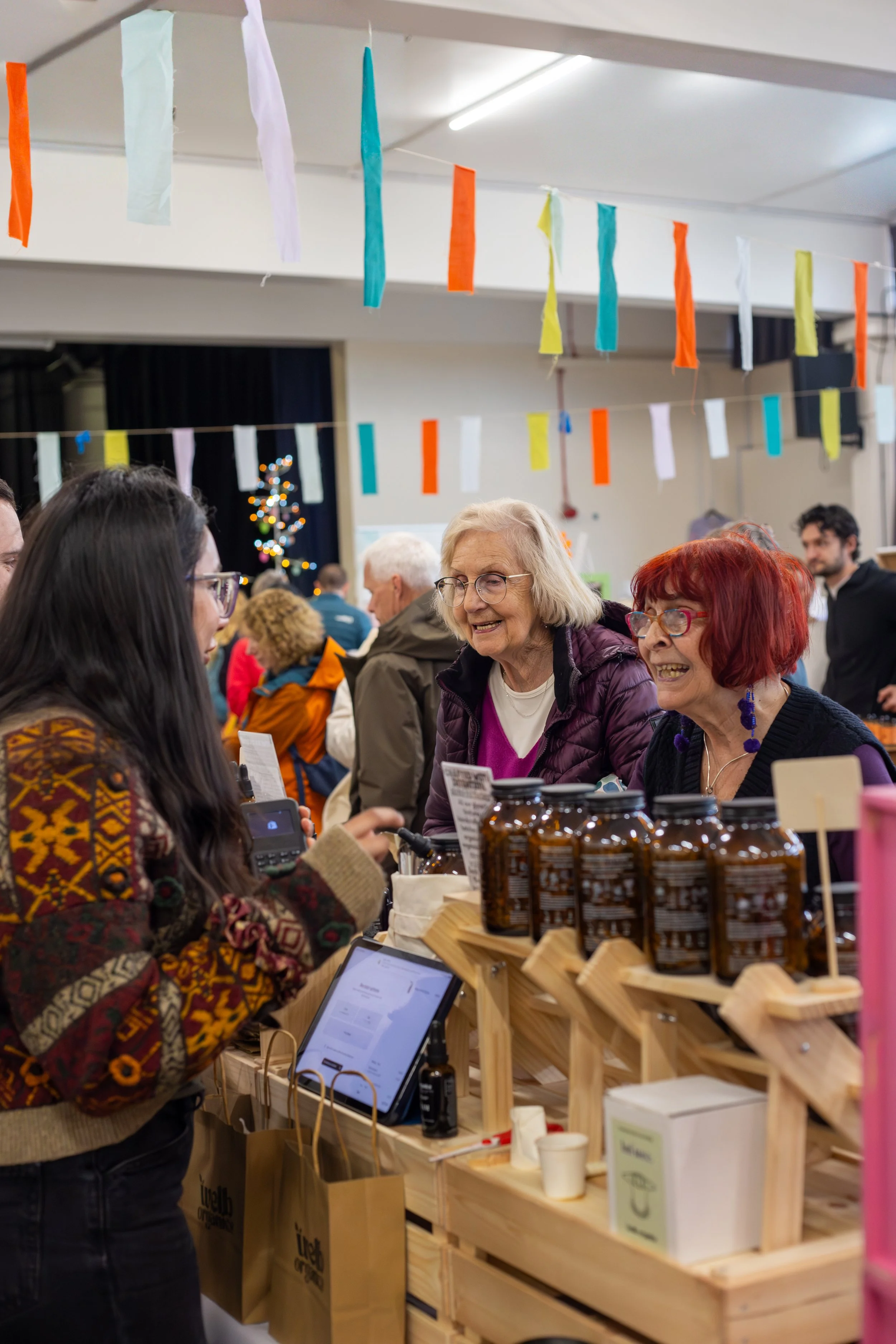 Visitors chatting with an independent wellness maker at the Shoreham Christmas Makers Fair.