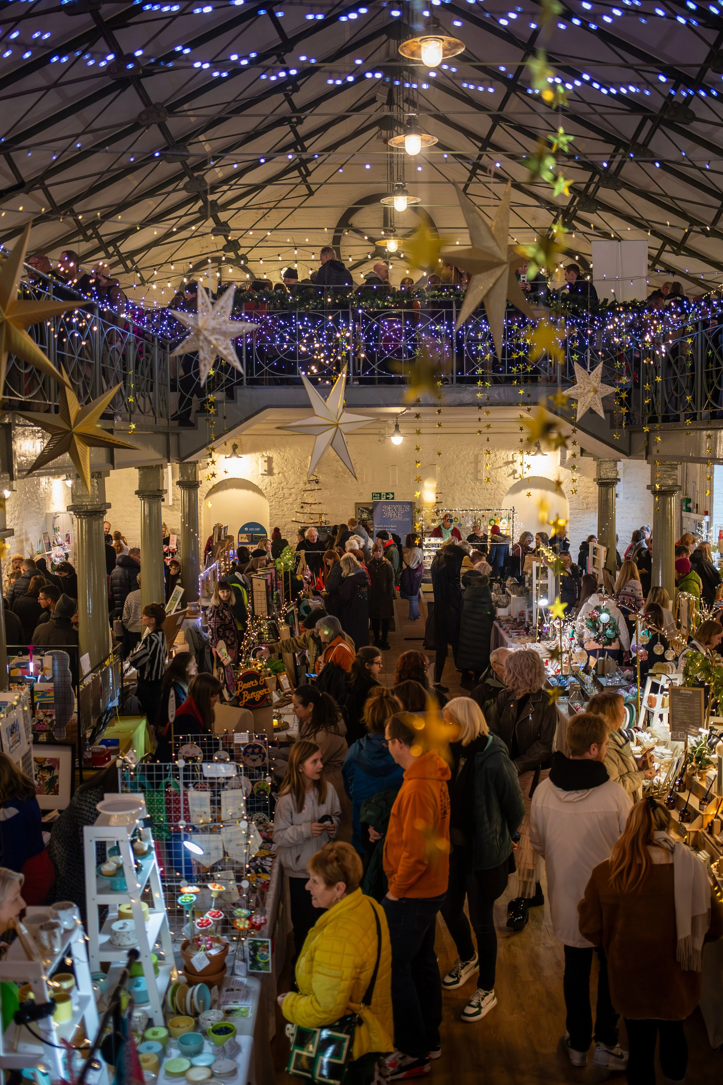 Visitors exploring the Winter Makers Fair surrounded by festive decor and twinkling fairy lights