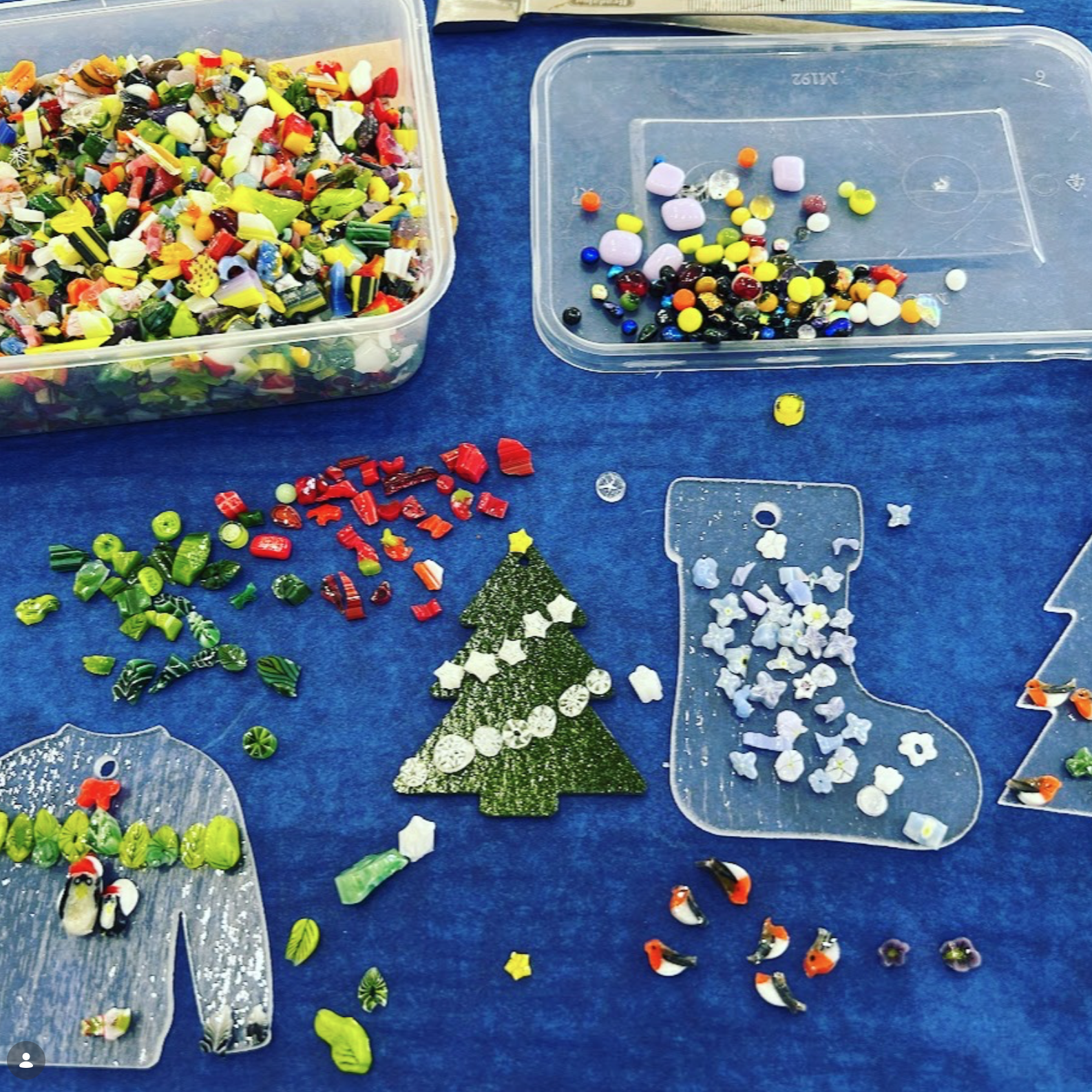 GLASS WORKSHOP TABLE WITH CHRISTMAS DECORATIONS AND DECORATIVE GLASS PIECES