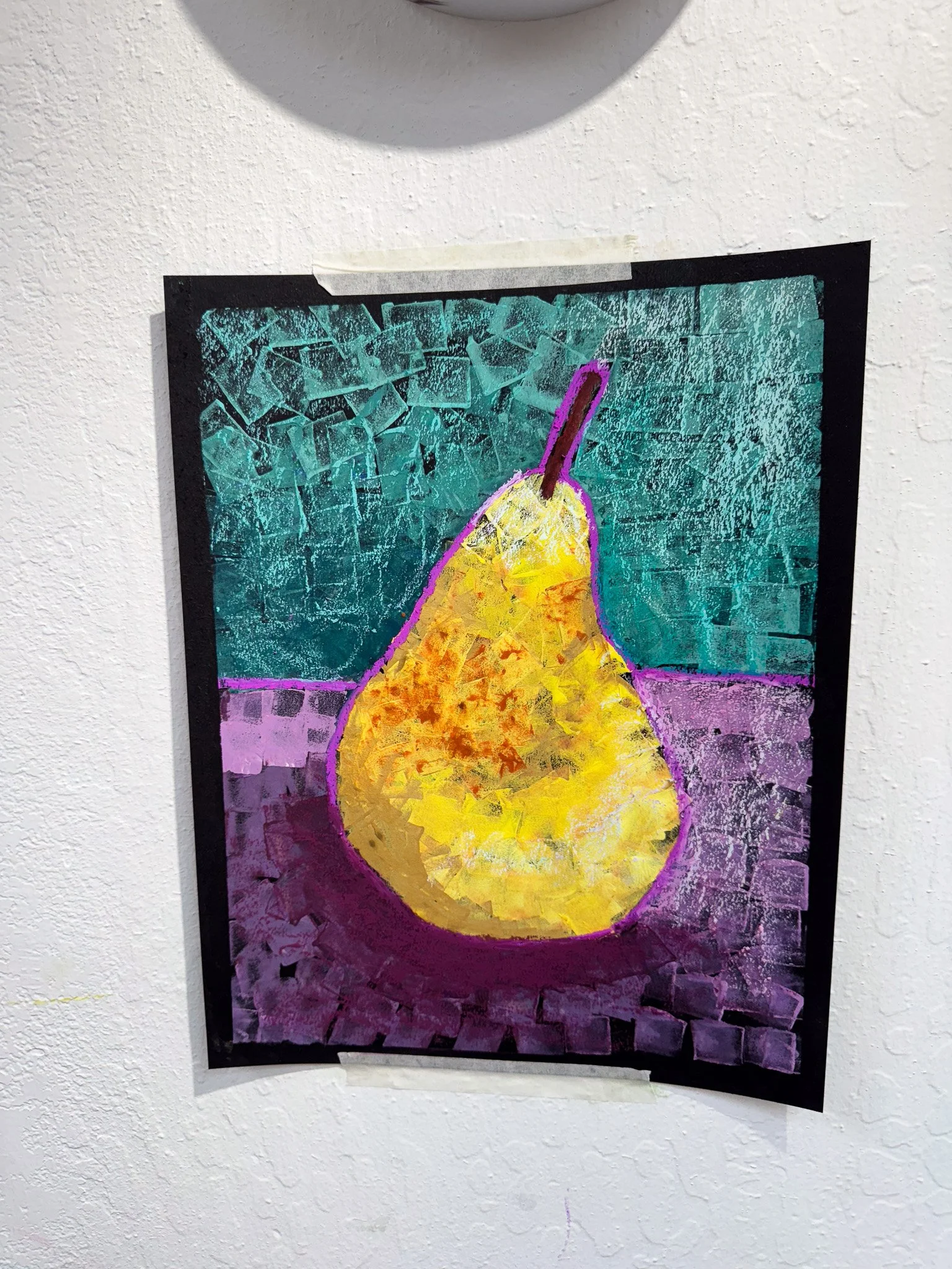 A colorful painting of a yellow pear with a purple outline, placed on a purple and green background, taped to a white wall.