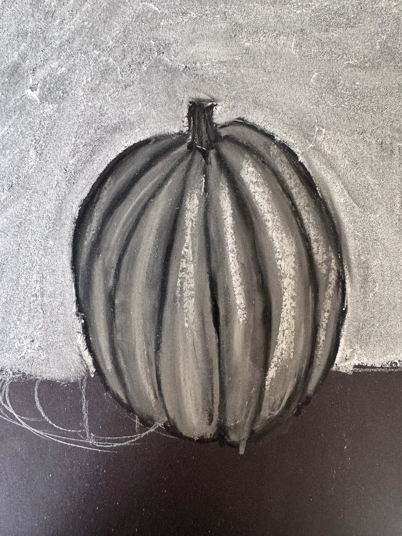Black and white charcoal drawing of a pumpkin against a textured background.