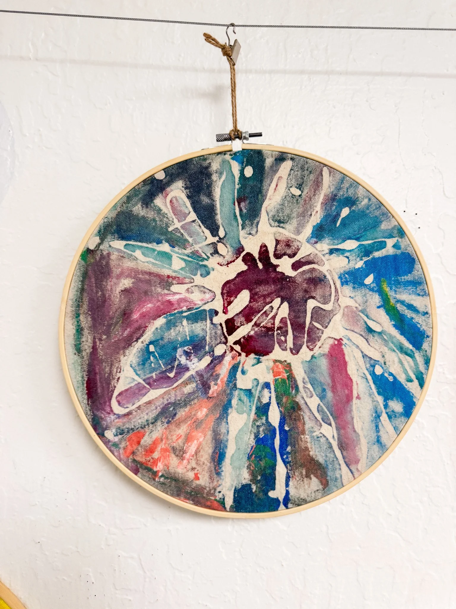 Colorful abstract painting with a silhouette of two people holding hands in the center, surrounded by vibrant streaks of paint.