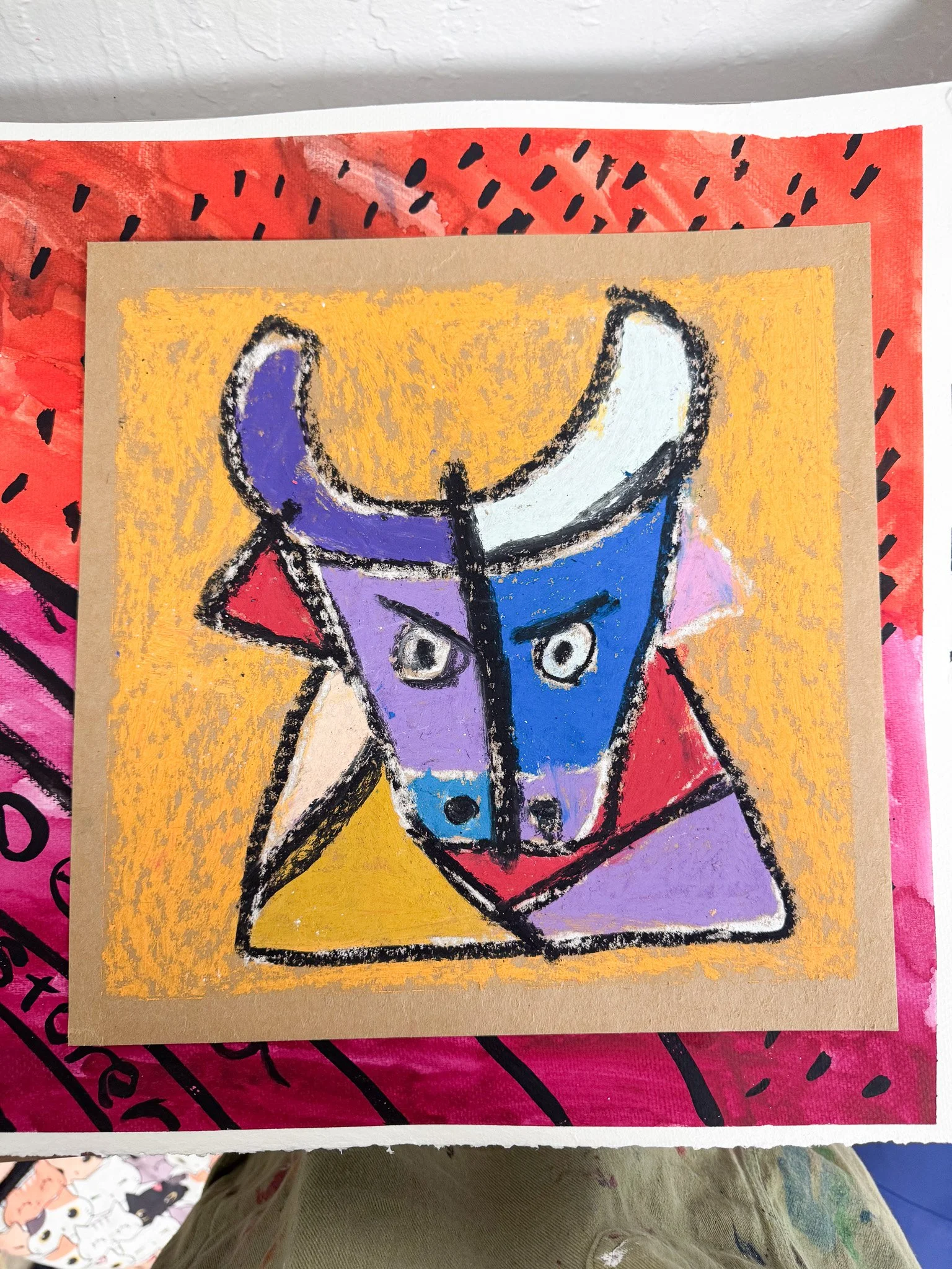 Abstract drawing of a bull's head with bold black outlines, mainly in purple, blue, red, and yellow, on a textured yellow background, with a red and pink border.