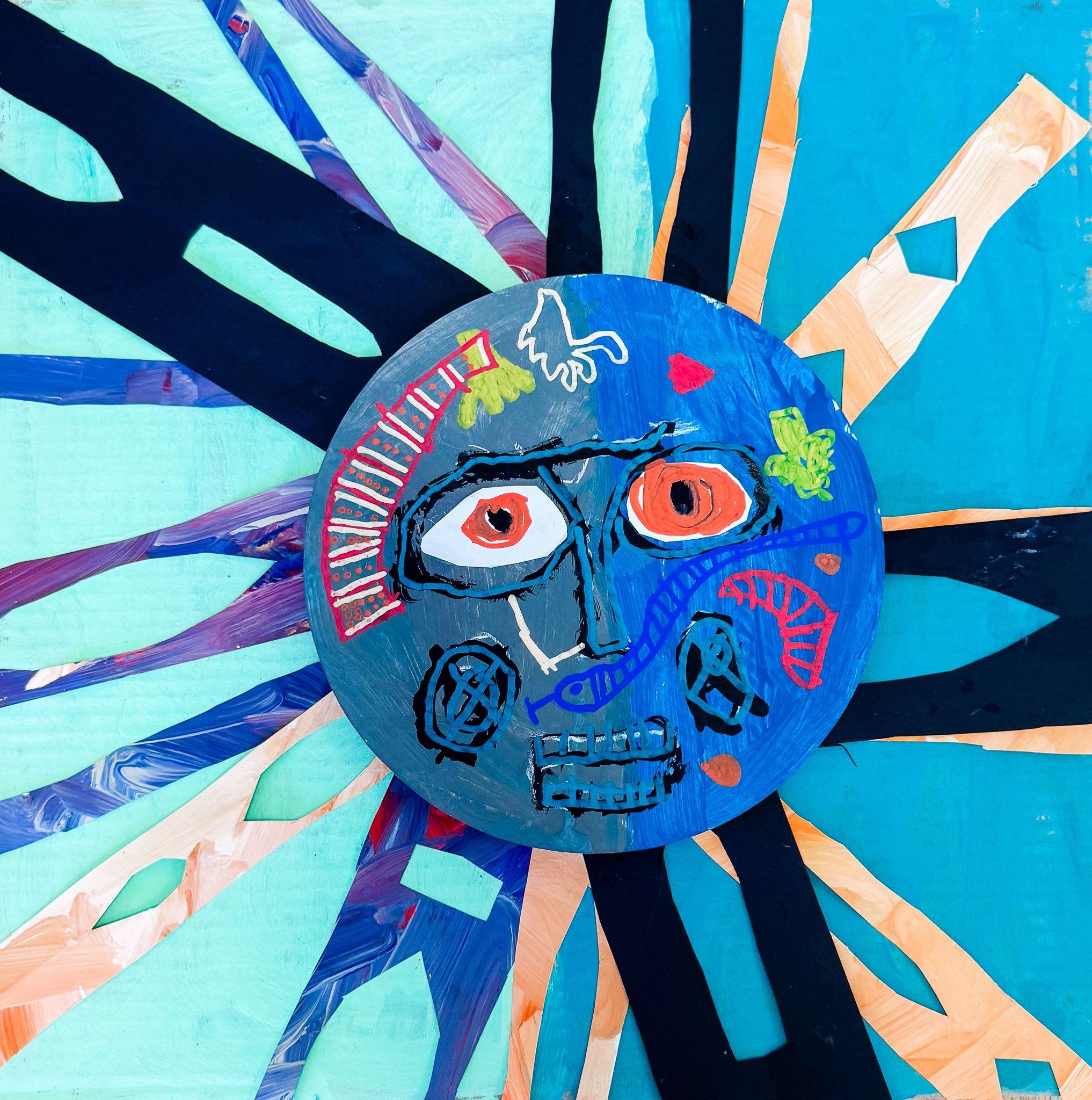 Colorful abstract artwork with a round face resembling a skull, featuring large orange eyes, a blue nose, and a zigzag red mouth, surrounded by various small colorful shapes and lines with a background of radiating striped patterns in shades of blue,