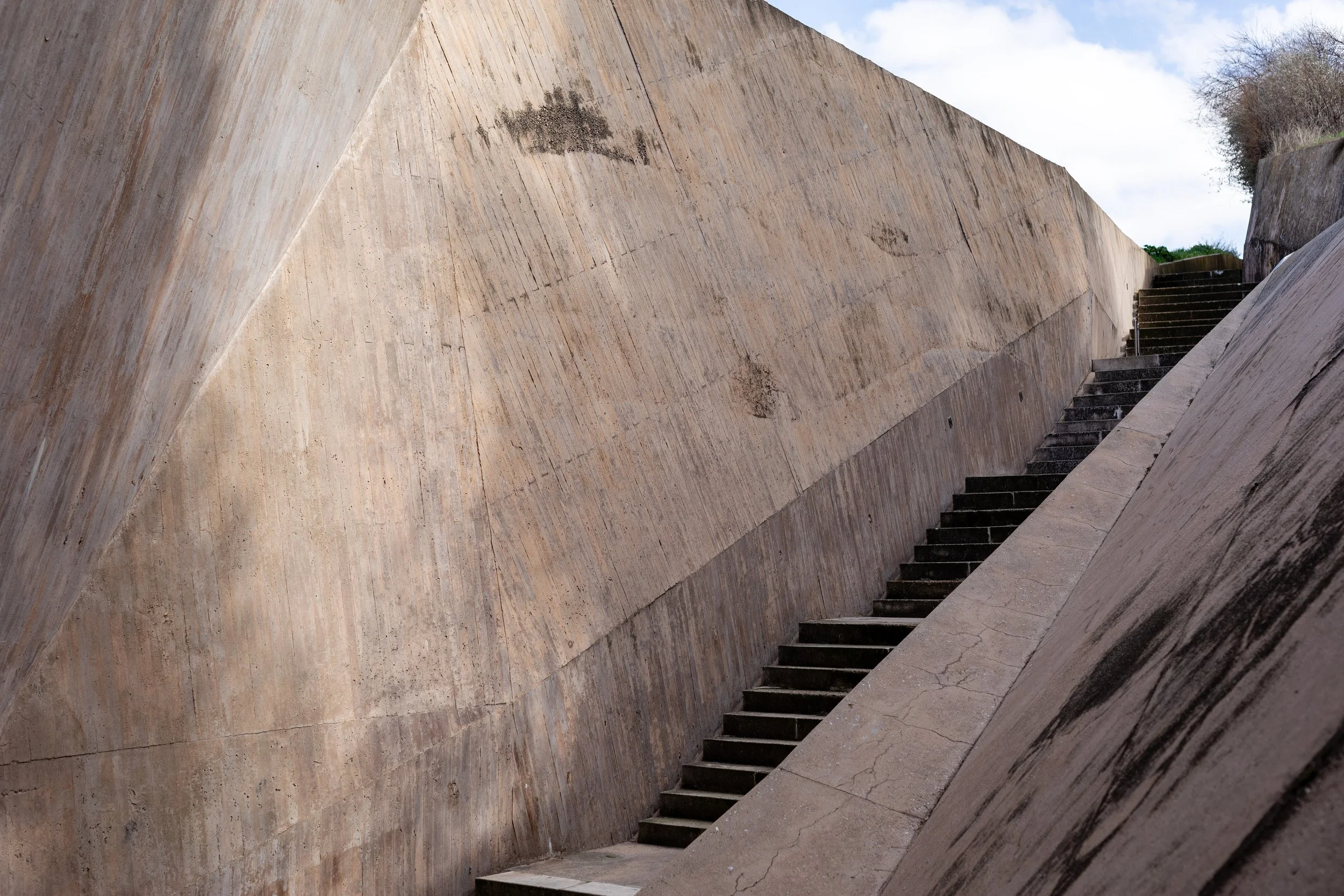 Concrete staircase between sloped walls outdoors