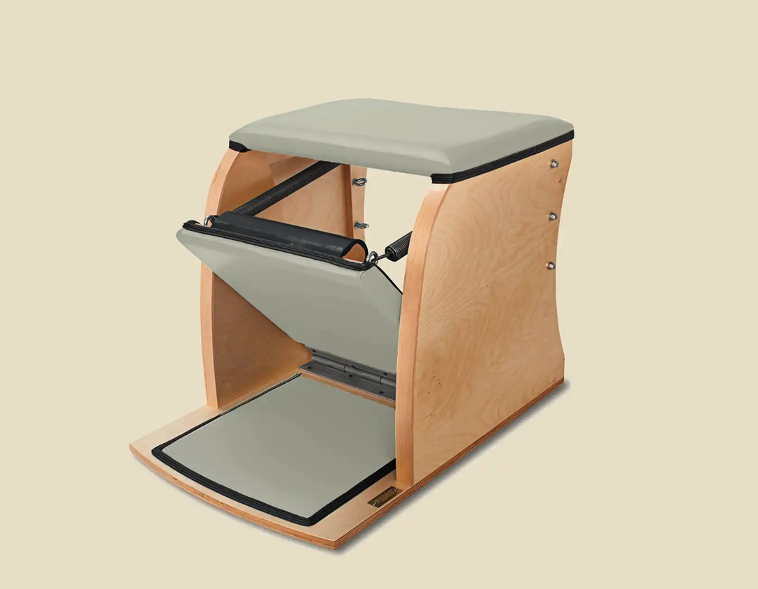 Image of a Classical Pilates Wunda Chair with a wood frame and sage green upholstery