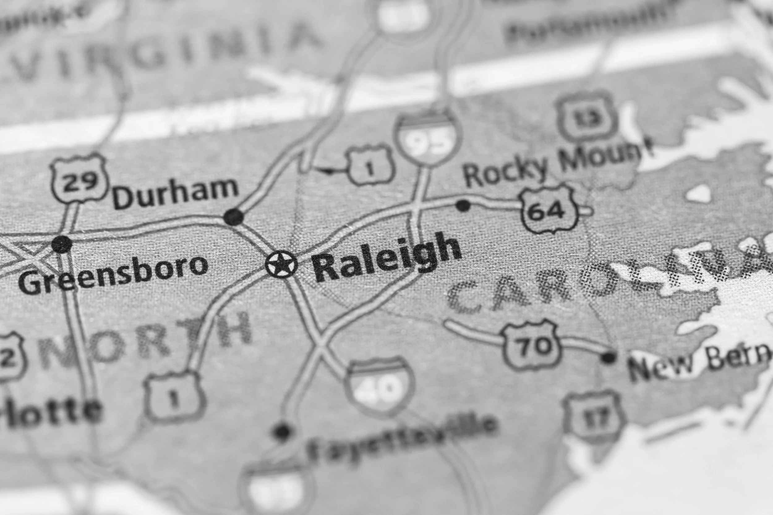 Map showing Raleigh, North Carolina, and surrounding cities including Durham, Greensboro, Charlotte, Fayetteville, and New Bern, with major highways and roads.
