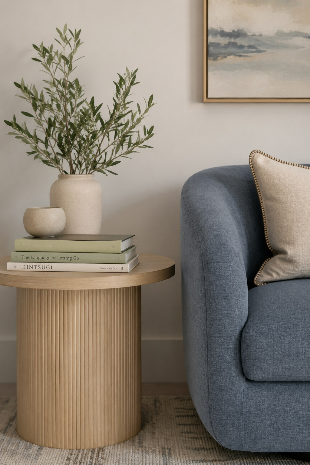 Warm talk therapy office with a blue velvet sofa, neutral furnishings, soft lighting, and calming artwork.