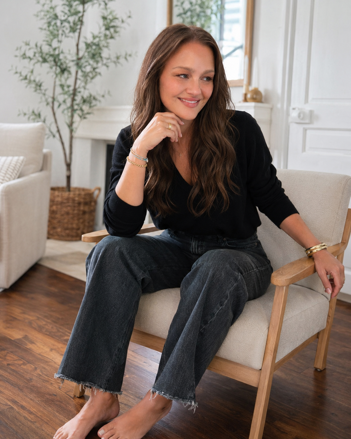 Elizabeth sitting in a chair with head resting on hand with a smile.
