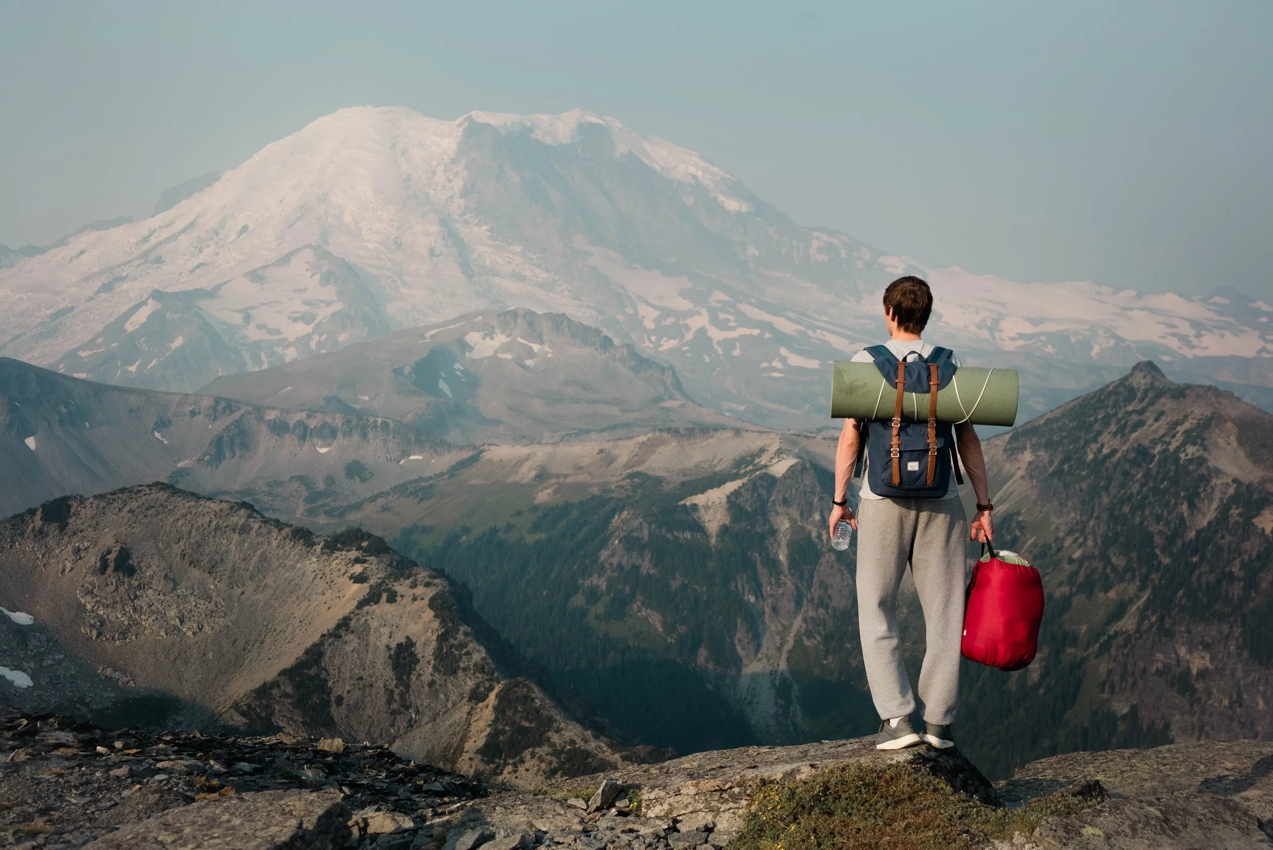 A person with a backpack walking through the mountains.