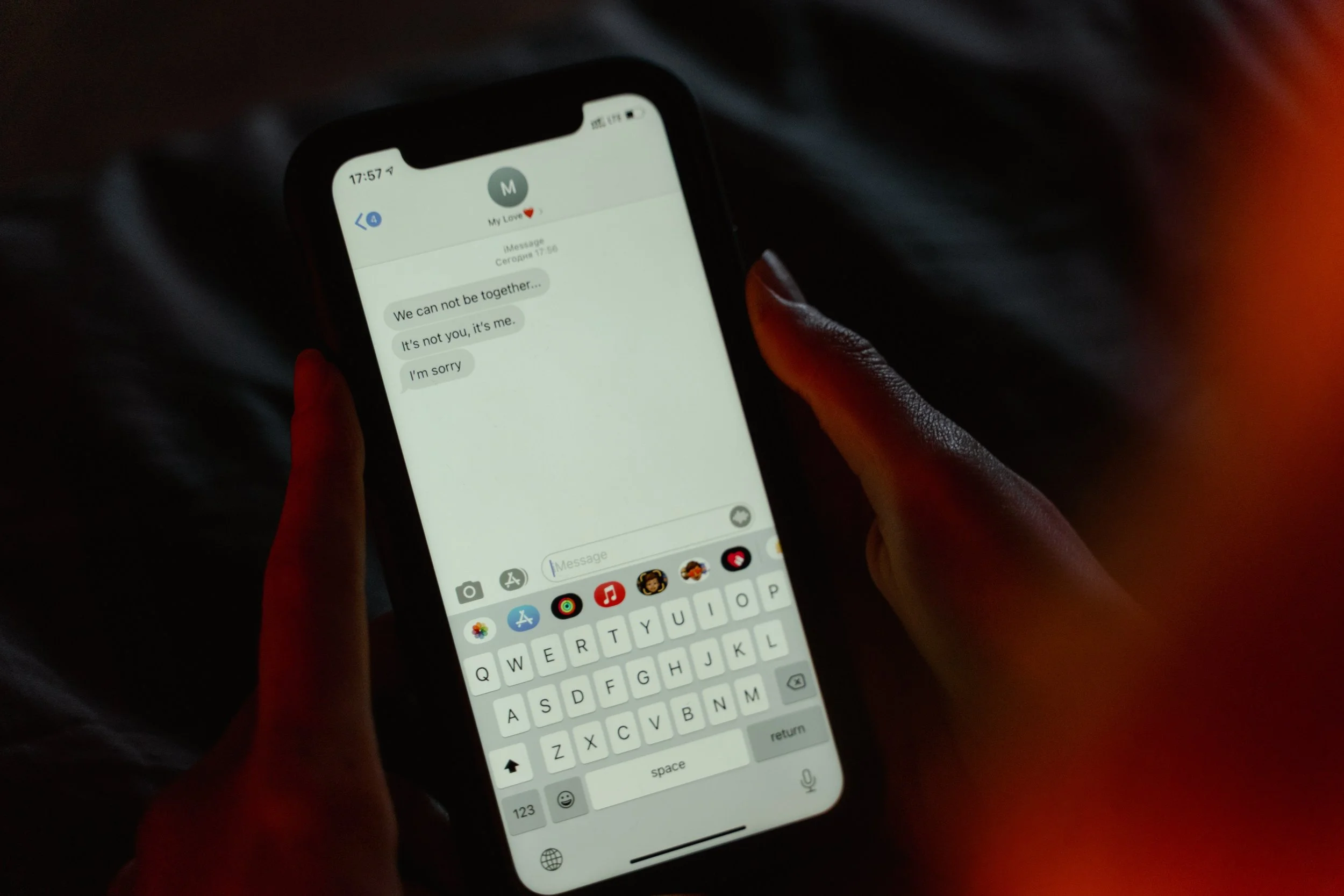 A phone with a text message that says, "We can't be together. It's not you it's me. I'm sorry."