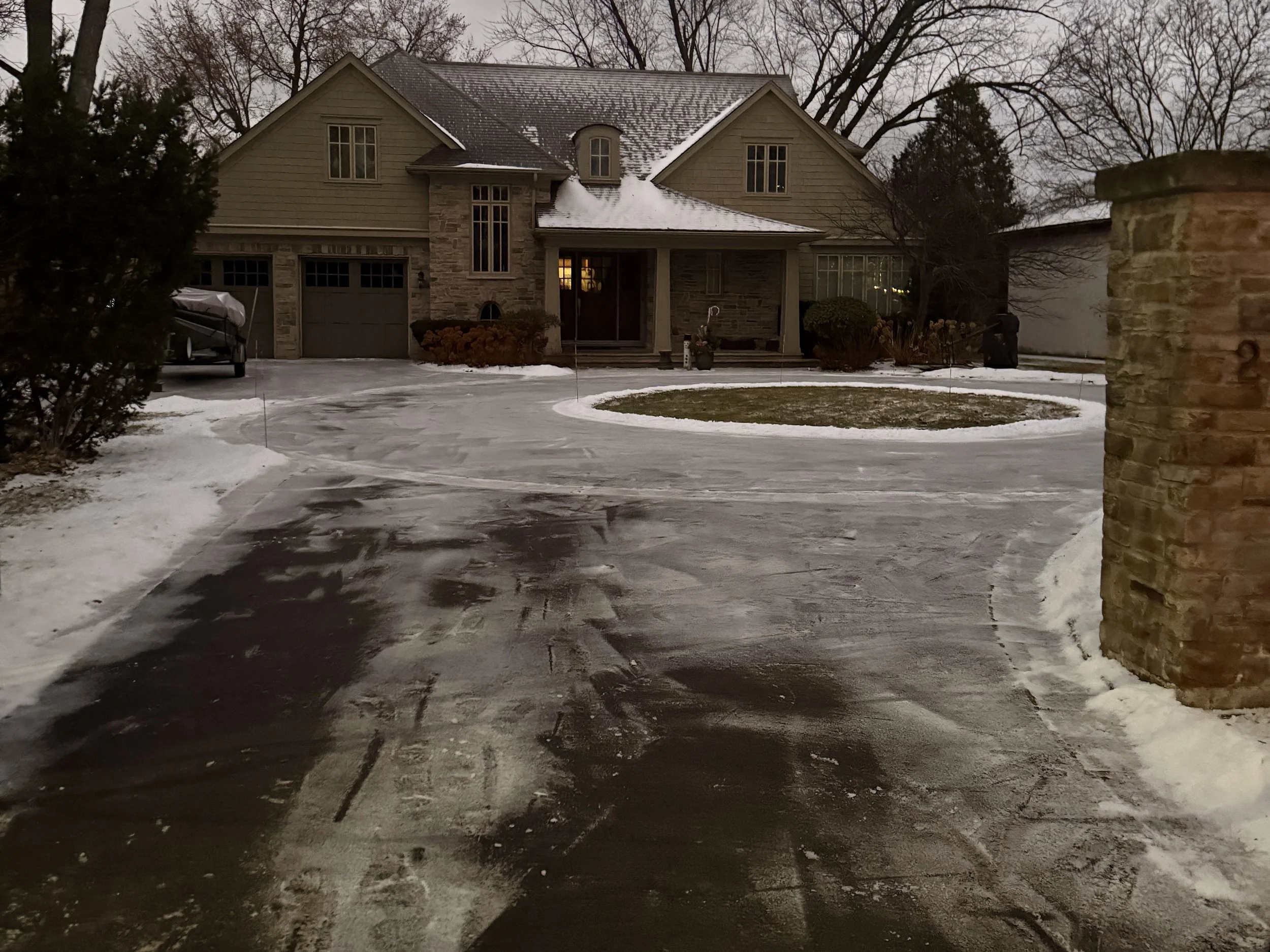 Residential snow removal in Oakville with shovel and snow blower clearing a private driveway