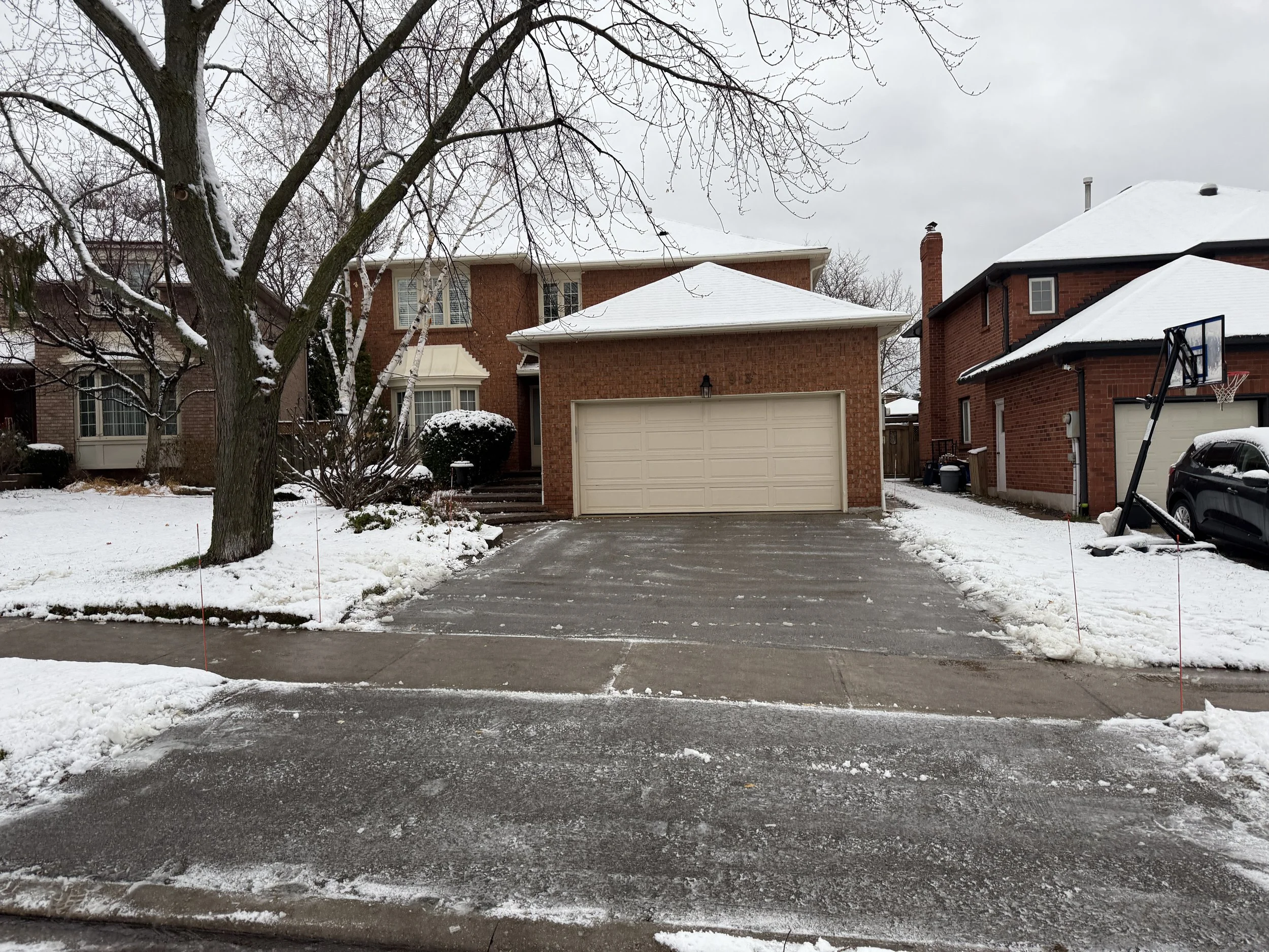Snow removal completed in the Glen Abbey neighbourhood in Oakville, Ontario. Shovel and blower service, with driveway markers.