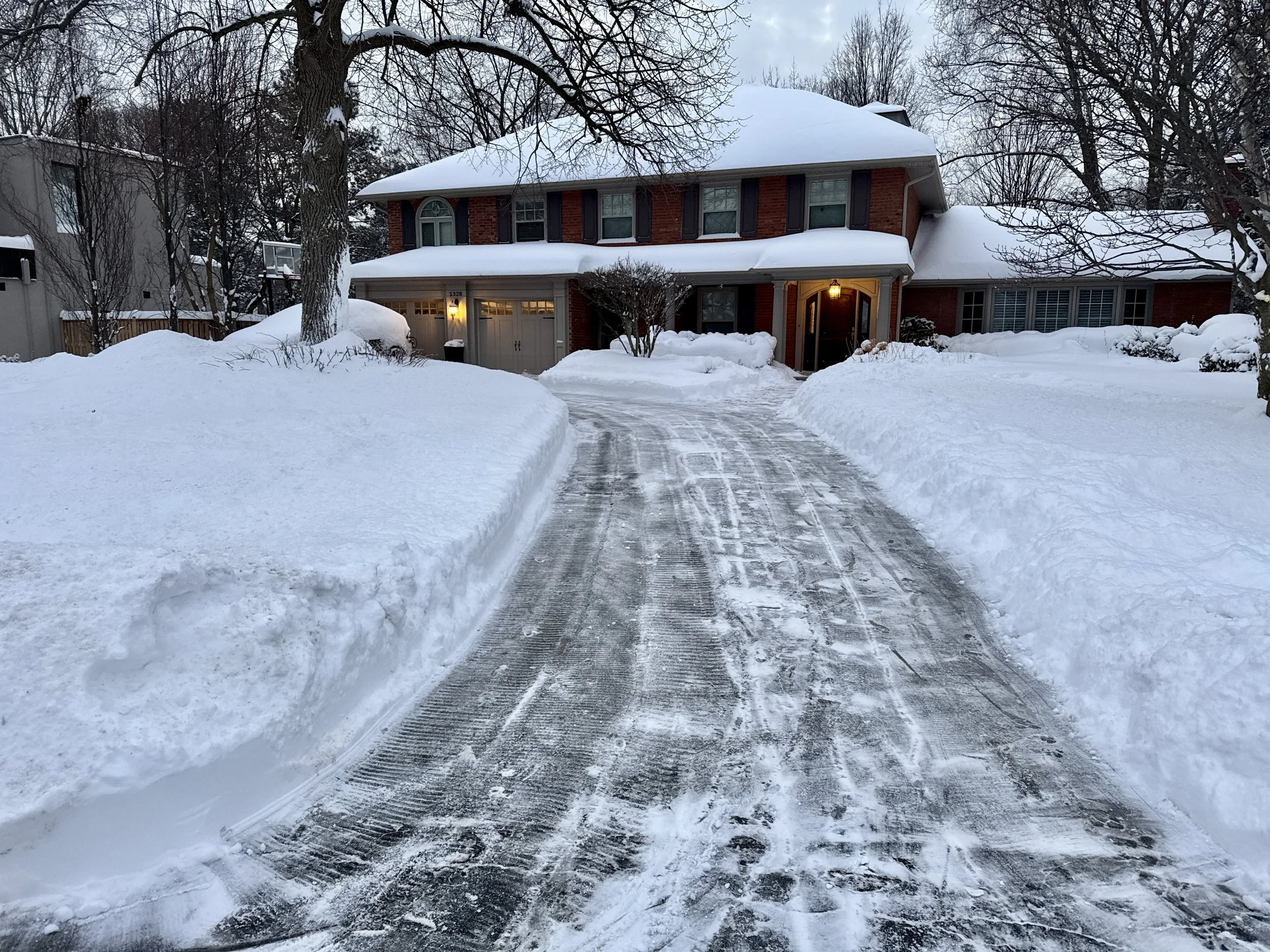 Driveway cleared in south east Oakville after heavy snowfall, using blowers and shovels.