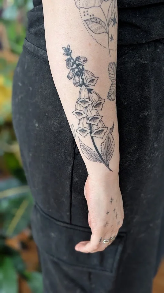 Healed foxglove tattoo on clients forearm