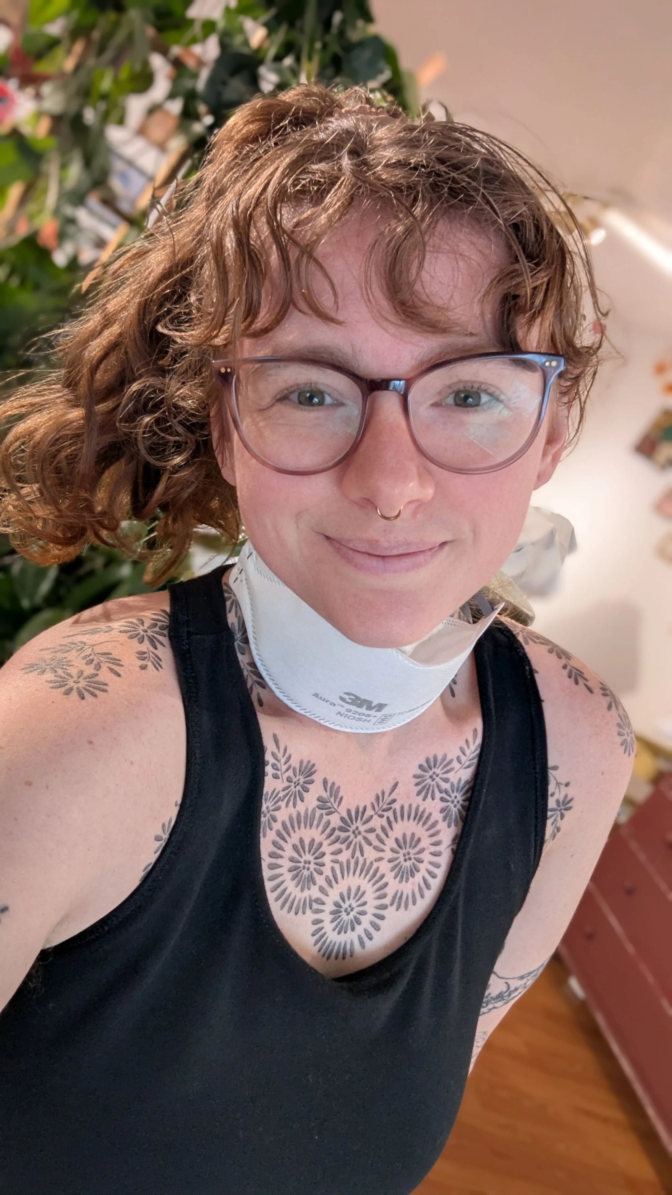 A picture of Rayla, she is a white woman with curly red hair and visible tattoos.