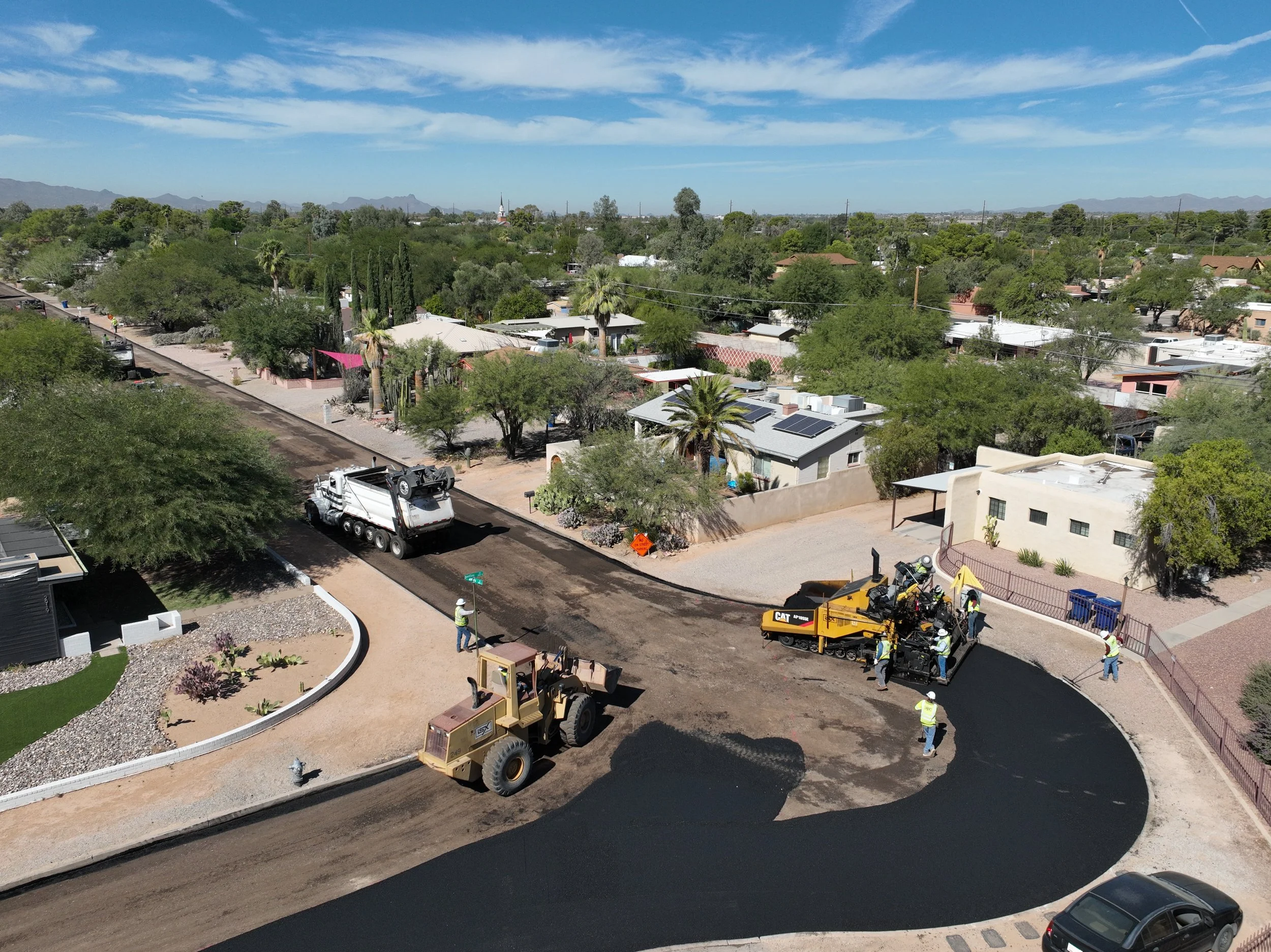 iSX staff paving a street with asphalt in a Tucson neighborhood.