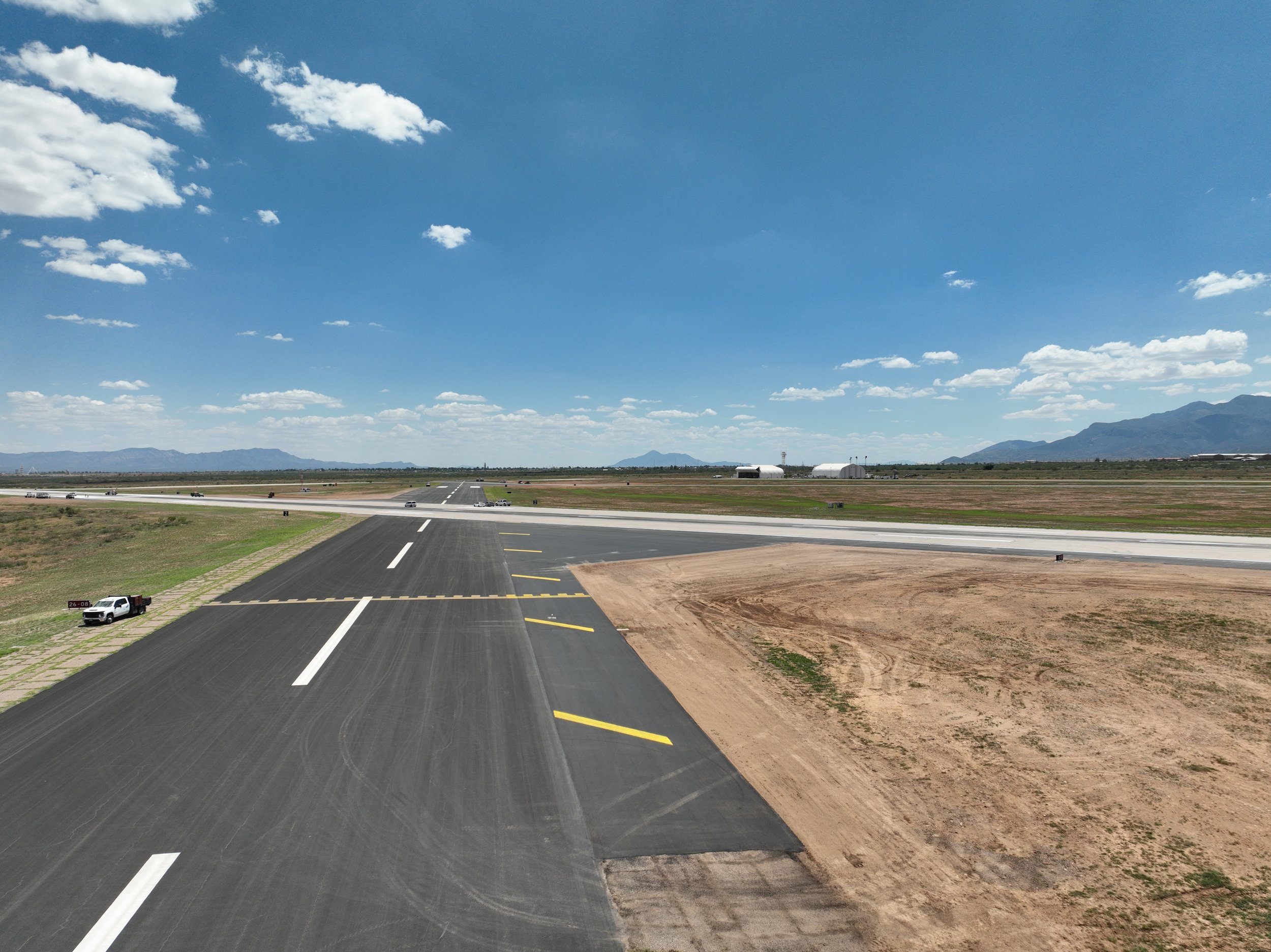 Asphalt shoulders along a taxiway and runway completed