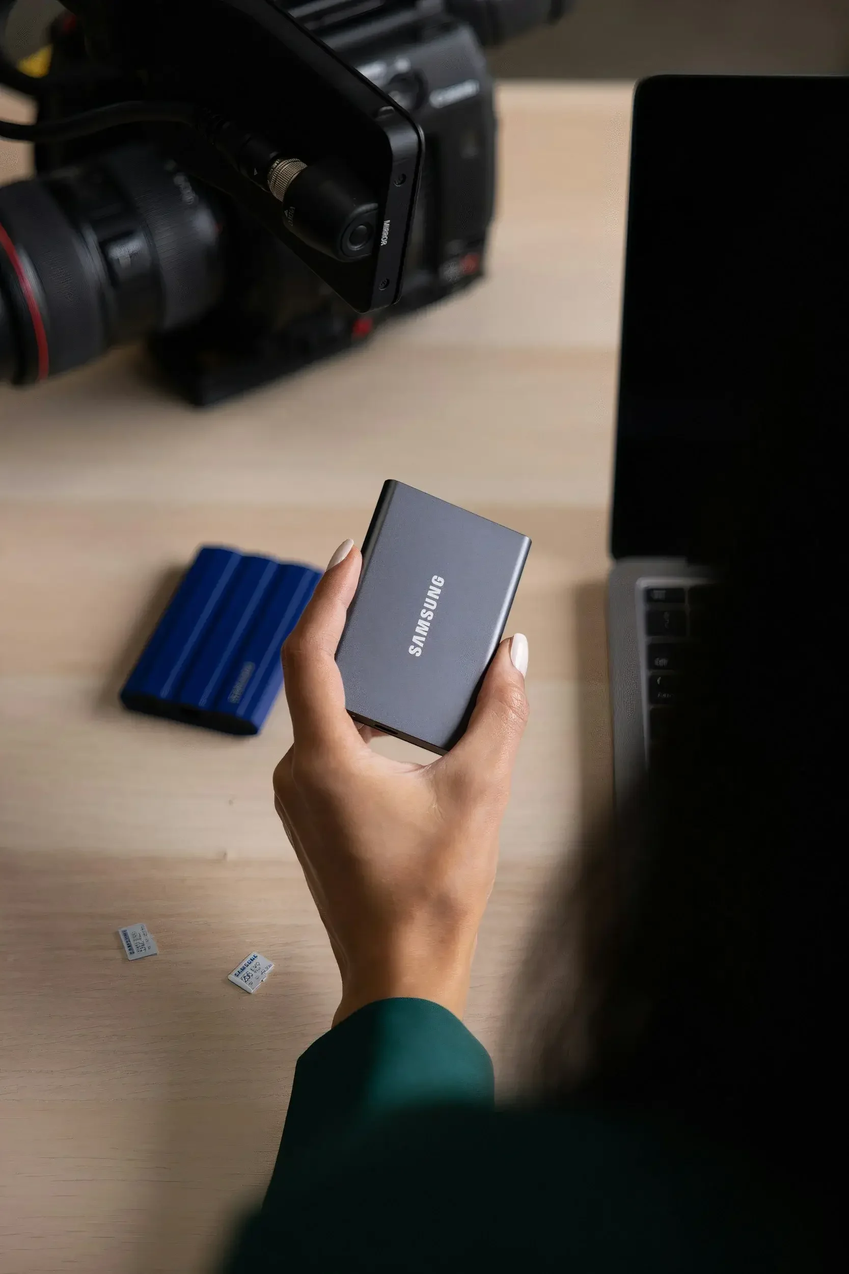 person holding what's looking like a Samsung external hard disk