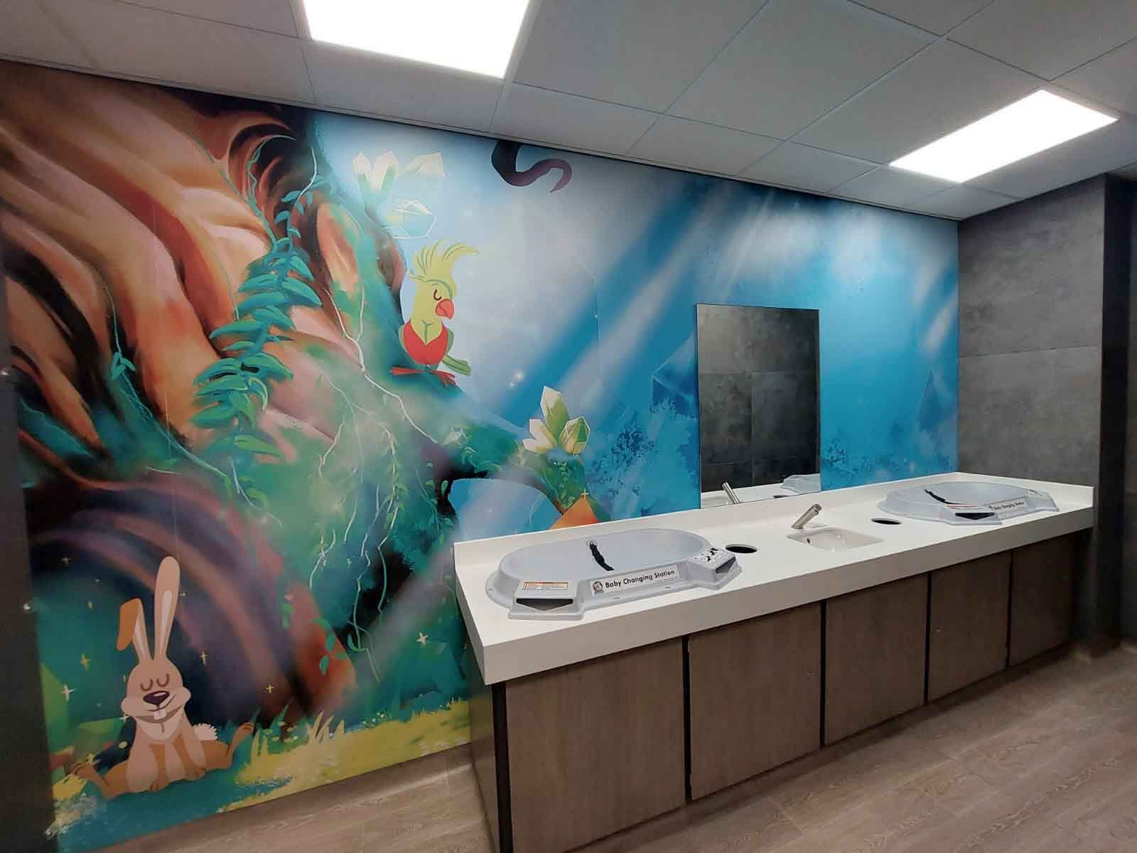  washroom with baby changing unit and wall mural 