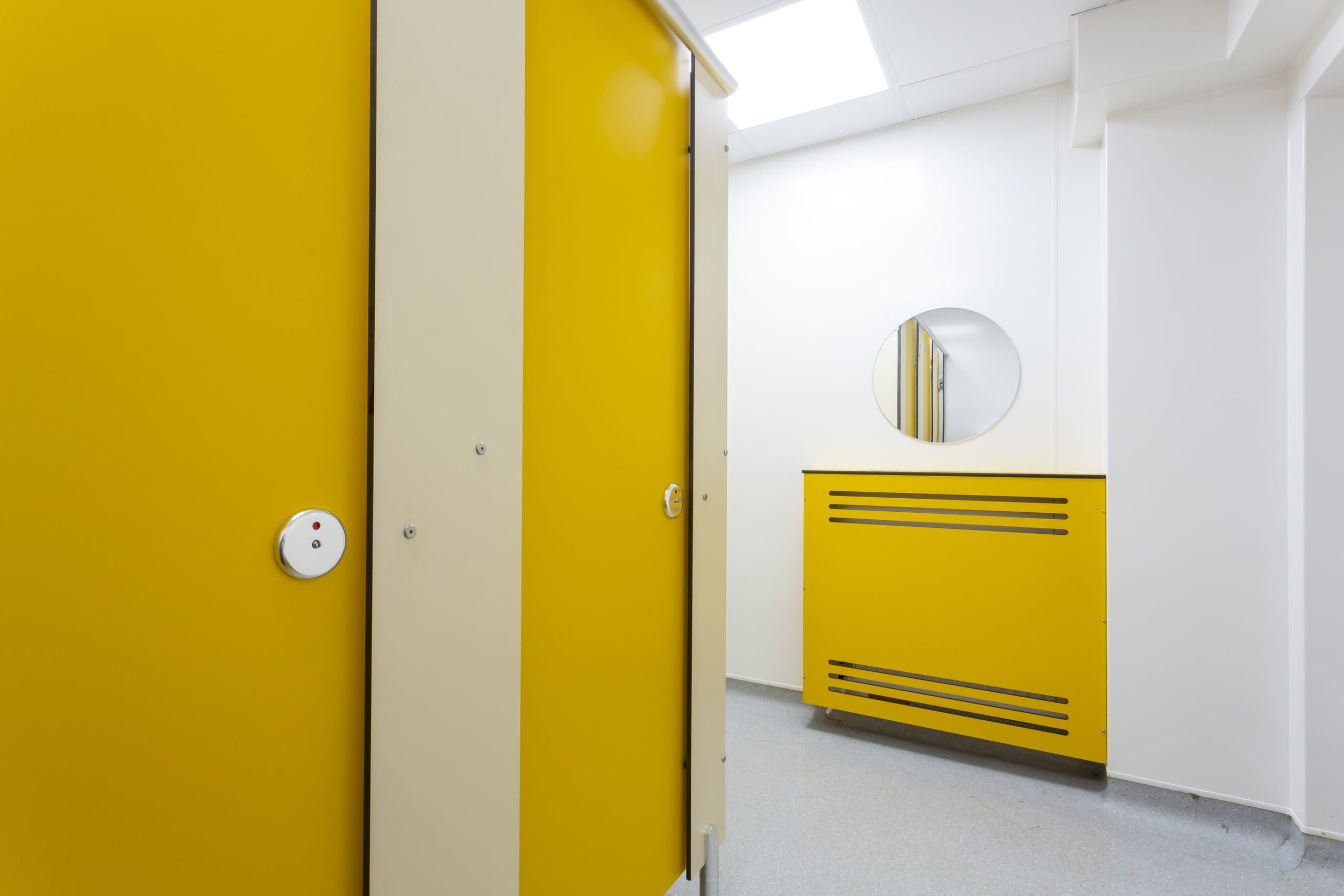 yellow and white toilet cubicles and a radiator cover at cliff park school.jpg