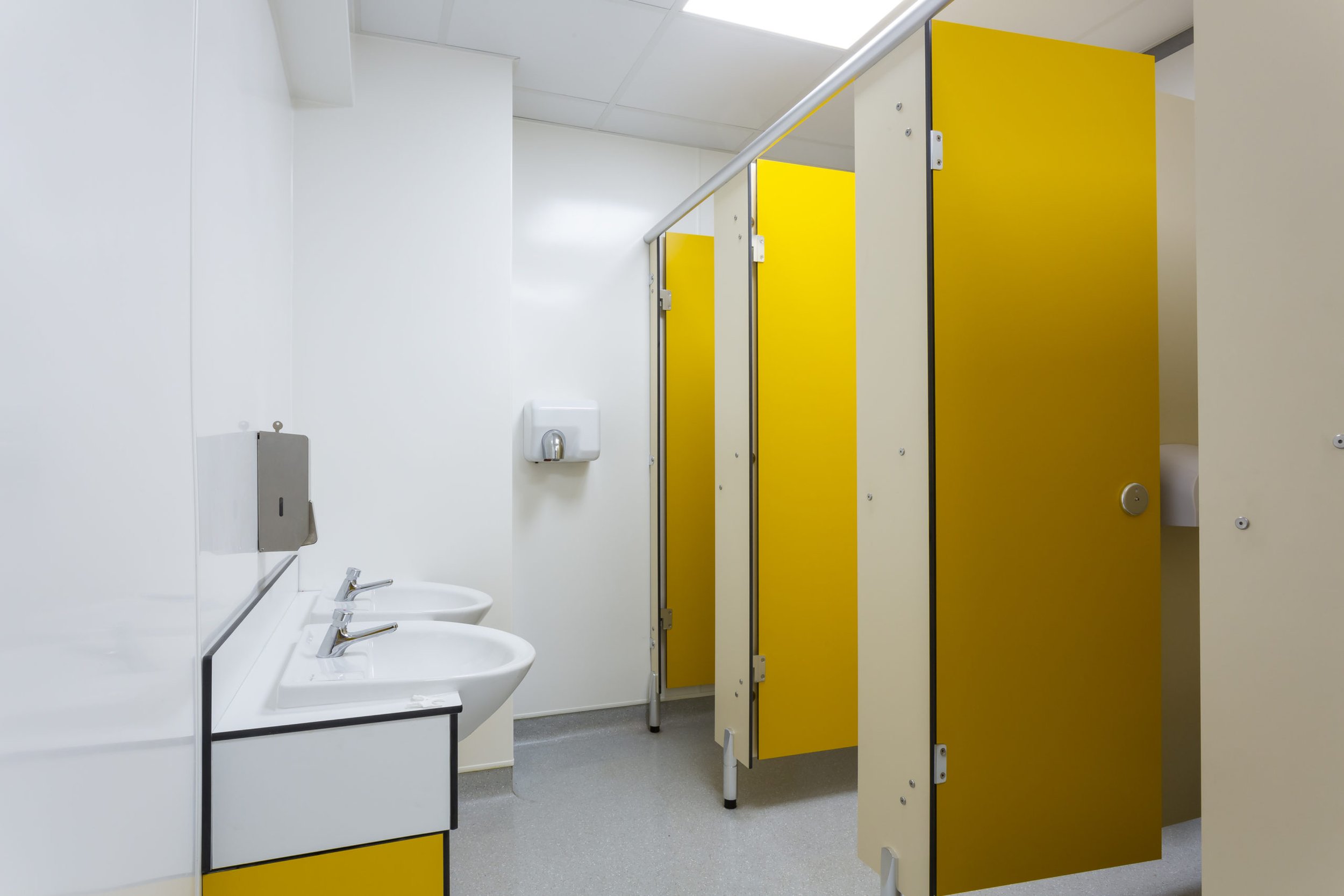 yellow and white toilets and vanity unit and sinks at cliff park school.jpg