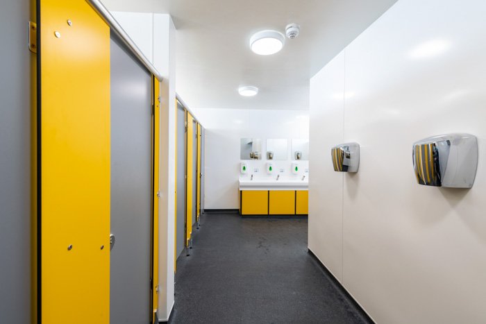 yellow and grey toilets with a hand wash vanity unit and hand dryers at southwold pier.jpg