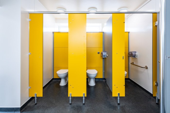 bright yellow cubicles with duct panels at southwold pier public toilets.jpg