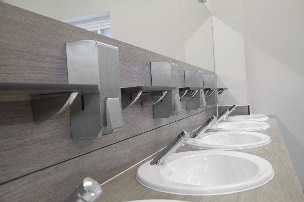 Vanity top with recessed sinks and soft touch taps and a spashback with shelving and soap dispensers.jpg