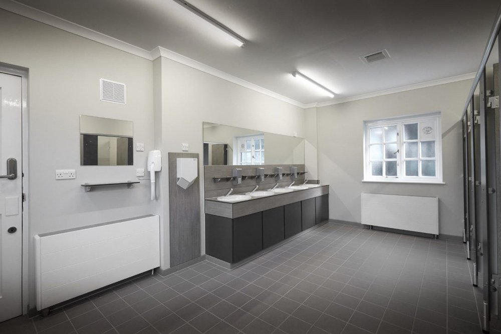 a washroom with a vanity unit and sinks with splashback and a hairdryer and mirrors at waterclose meadows campsite.jpg