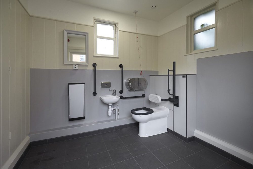 doc m disabled toilet with grey half height hygienic wal cladding and tiled floor at hughenden manor.jpg