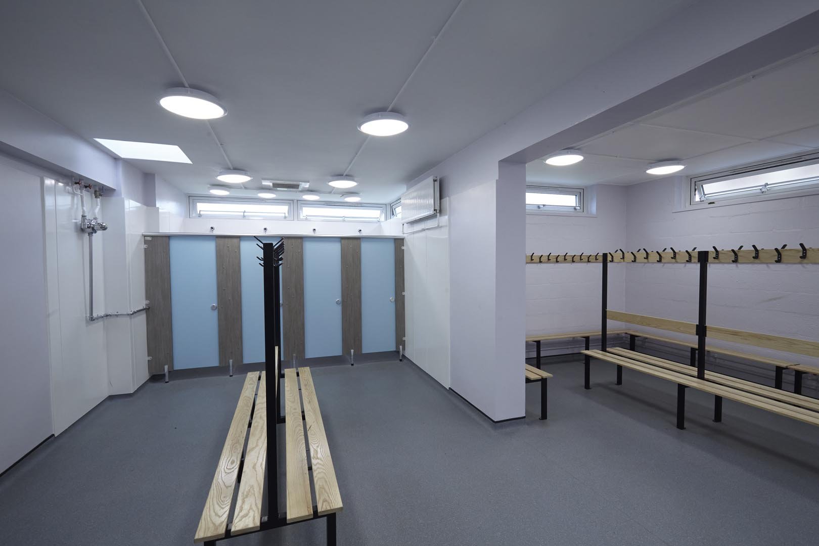 changing room with blue shower cubicles and benching at churchead school.jpg