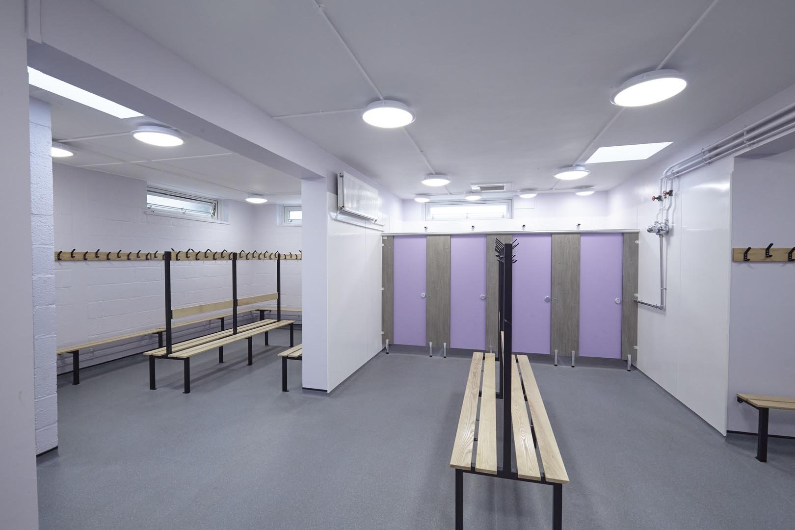 changing room with shower cubicles in purple and benching at churchmead school.jpg