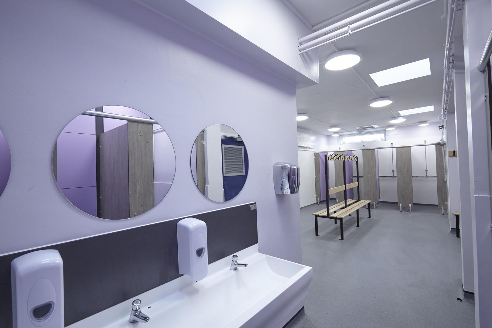 vanity hand wash trough with mirrors above and changing room at churchmead.jpg